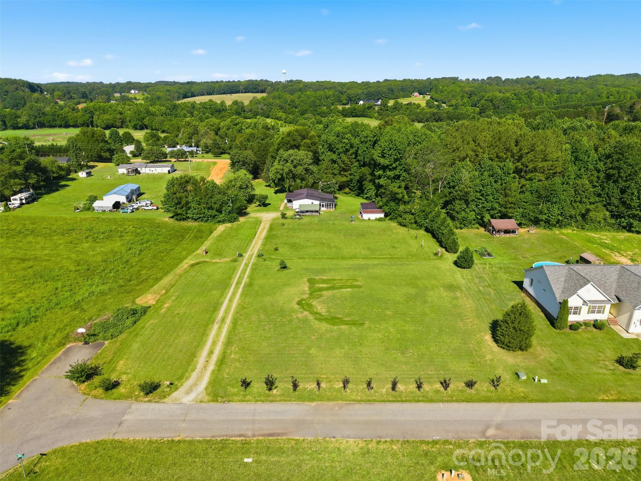 Experience peaceful country living with exceptional convenience at this charming 3-bedroom, 2-bath home on Sugarfarm Road in Catawba. This property also includes the adjoining vacant lot, offering expanded space, privacy, and future potential that’s hard to find in today’s market.

Surrounded by open land, mature trees, and the quiet beauty of rural North Carolina, this home provides a private retreat while still offering quick access to Hwy 16, I-40, Lake Norman, and the surrounding Catawba County communities.
Inside, you’ll find warm, inviting living spaces filled with natural light and a layout designed for comfort and functionality. The kitchen features generous storage and workspace, while the bedrooms offer flexibility for family, guests, or a home office. The outdoor setting is a standout — enjoy a spacious yard ideal for gardening, pets, or play, along with ample room for parking, hobbies, or future additions such as a workshop, garage, or outdoor living area. Three storage buildings are included, two of which already have power connected, adding even more versatility. The rural setting provides privacy and freedom without sacrificing accessibility. For the best access to the home, please navigate using 5660 Aspirán Drive, Catawba, NC, which crosses the adjoining vacant land and offers the most direct and convenient approach. A wonderful opportunity to enjoy space, serenity, and the comfort of country living in the heart of Catawba. Home being sold As Is.