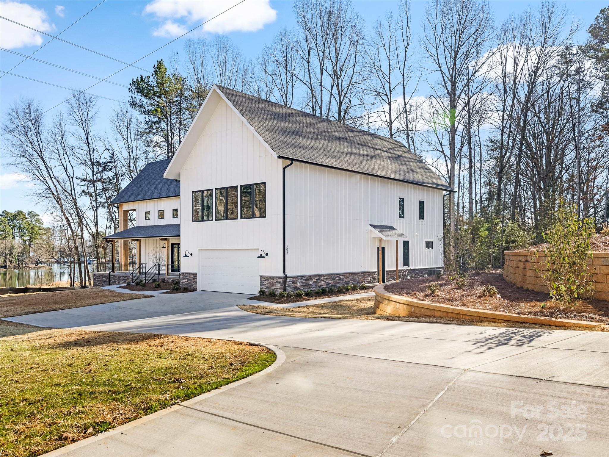 New construction, Custom waterfront modern farmhouse "Barndominium" located on Lake Wylie just minutes from the Boyd Bridge.  This unique property blends rustic charm with contemporary elegance, offering the perfect retreat from everyday life. Open-concept living area with 32 ft ceilings and large windows that flood the space with natural light and provide stunning views of the lake.  Gourmet kitchen with quartz counter tops, custom cabinetry, massive walk-in pantry, and a large island perfect for entertaining.  Primary bedroom on main adjoins spacious laundry room.  Huge 3+ car  garage and wrap-around covered porch. Custom closets and gorgeous light fixtures throughout. Upstairs features 3 more bedrooms, 2 full baths and a GINORMOUS rec room, perfect for work outs, movie nights or sleep overs!  Enjoy this beautiful home with direct access to waterfront area with beach and fully refurbished rip rap, no HOA. Dockable shoreline area to add your own dock on this deep water cove.