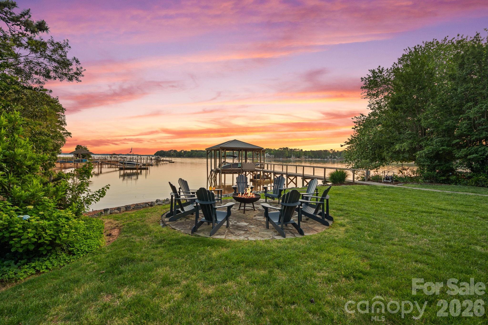 Tucked away on the highly coveted Isle of Pines Peninsula, just off the main channel of Lake Norman, 107 Beachview Drive offers a rare blend of privacy and a beautifully lake-inspired waterfront residence. Set on a oversized 1-acre lot with nearly 200 feet of shoreline, this beautifully renovated 4-bedroom home showcases over 4,100 square feet of thoughtfully designed living space with expansive lake views from nearly every room. Fully reimagined in 2019, the home features a stunning chef’s kitchen with custom cabinetry, quartz countertops, high-end appliances, pizza oven and a generous island that flows seamlessly into light-filled living and dining spaces designed to capture the water views & beyond. The main-level primary suite offers a true retreat with a spacious, spa-inspired bath and oversized walk-in closet, while additional bedrooms and flexible spaces provide ideal accommodations for guests, office, or recreation. Outdoor living flows naturally from the home to a covered pergola deck, screened porch, and landscaped yard that leads to the water’s edge, where a covered dock with seating and year-round deep water invite easy lake days and gorgeous sunset evenings. Don't miss the rare advantage of a "grandfathered" boat ramp and private beach; features hard to find on Lake Norman. Located near waterfront dining, 3 Golf Courses & TNGC Charlotte this no-HOA property combines convenience with a peaceful setting, offering the ultimate Lake Norman lifestyle in one of the area’s most desirable locations, all within top-rated school districts.