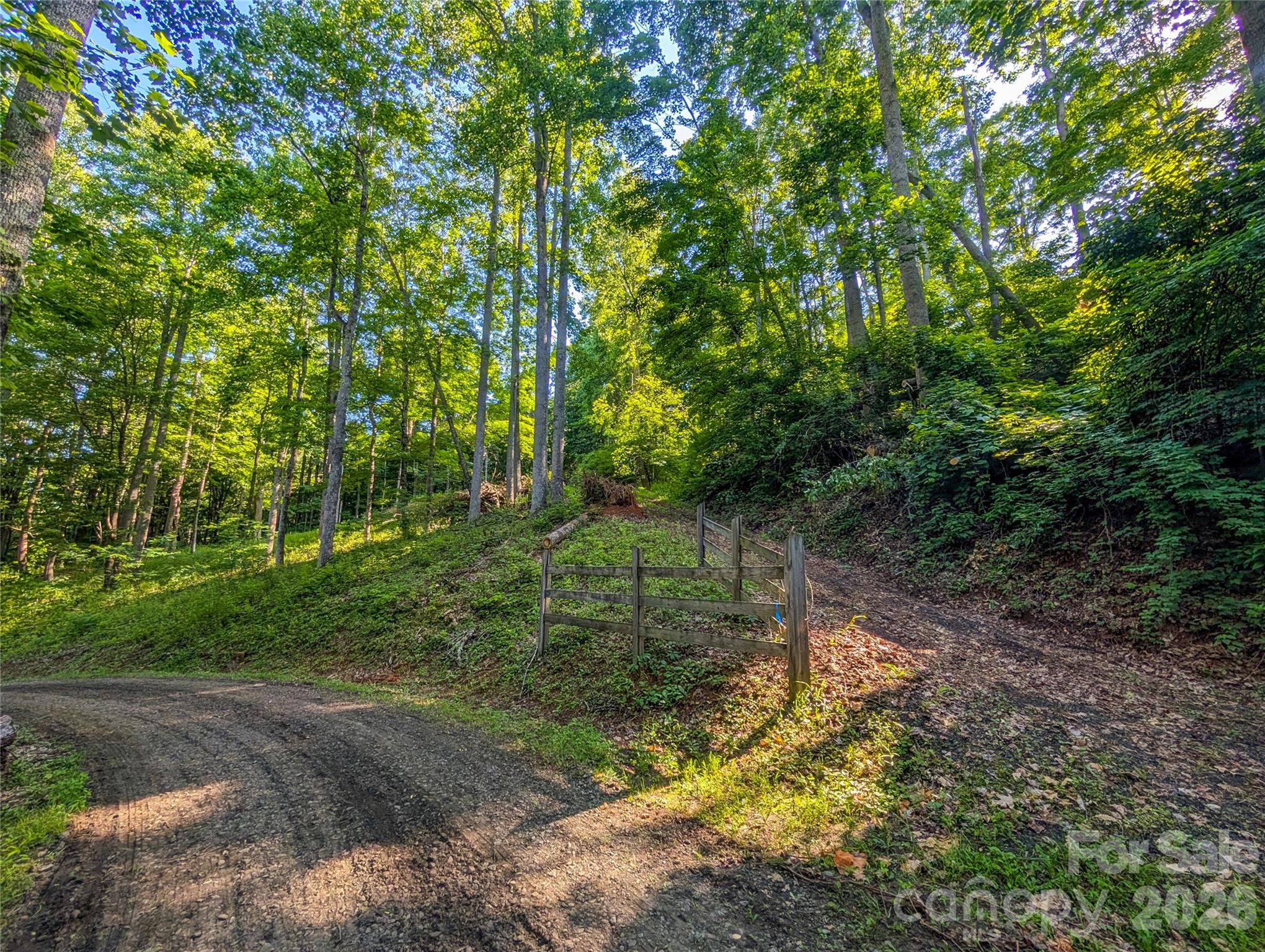 Tucked away in the peaceful Amber Ranches community of Bakersville, North Carolina, this beautiful 1.04± acre wooded homesite offers the perfect opportunity to create your own mountain retreat. Whether you're dreaming of a cozy cabin, a full-time residence surrounded by nature, or a private vacation getaway, Lot 47 provides a wonderful canvas to bring your vision to life. A short gravel/dirt driveway leads to a cleared, level building site, offering an ideal location for your future home while the remainder of the property gently sloping to sloped topography into a lush forest landscape filled with native hardwoods and seasonal mountain beauty. Wake each morning to the sounds of nature, breathe in the fresh mountain air, and enjoy the peace and privacy that make Western North Carolina so special. Located in the scenic Buladean area of Mitchell County, Amber Ranches is a quiet mountain community tucked away at the end of Broad Branch Road, yet conveniently positioned for both adventure and everyday convenience. You're just minutes from the Tennessee state line and approximately 21 minutes to downtown Bakersville, 31 minutes to Burnsville, 35 minutes to Spruce Pine, 40 minutes to Johnson City, Tennessee, and just over an hour to Boone, making it easy to enjoy shopping, dining, healthcare, entertainment, and outdoor recreation while returning home to the tranquility of the mountains. Outdoor enthusiasts will appreciate being just minutes from Roan Mountain State Park and access to the Appalachian Trail, countless hiking trails, waterfalls, trout streams, and endless opportunities for adventure all within easy reach. The surrounding area is rich with talented artisans, craft studios, local galleries, festivals, and the authentic mountain culture that makes Mitchell County one of Western North Carolina's hidden gems. Experience the beauty of all four seasons—from vibrant spring wildflowers and cool summer evenings to breathtaking autumn foliage and peaceful winter landscapes. If you've been searching for a place to slow down, reconnect with nature, and build the mountain home you've always imagined, Lot 47 in Amber Ranches is ready to welcome you home.