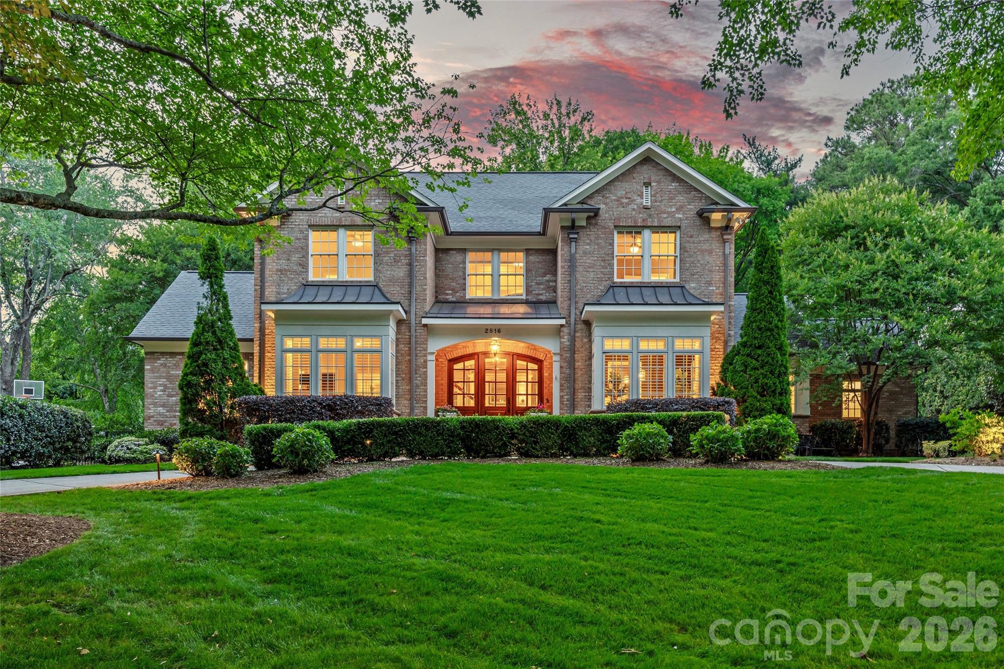 Welcome to this exceptional full-brick residence nestled in one of Charlotte’s most sought-after neighborhoods—Deering Oaks on a slightly elevated 0.63 acre beautiful lot. Custom built in 2012 by Kelly McArdle and architect, Miller Nicholson, this expansive home offers over 5,700 heated square feet of thoughtfully designed living space, blending timeless architecture with wonderful functionality. Step inside to find 10-foot ceilings throughout the main level and a layout designed for both everyday living and elegant entertaining. Inviting foyer and formal dining room with custom molding and bright bay window. Large family room with coffered ceiling, center gas log fireplace flanked with French doors leading to rear patio and beautiful built-in shelving. Gourmet Kitchen with large island, professional gas range and hood, corner window, built-in bar area from dining room, coffee bar with beverage fridge and walk-in pantry open to eat in breakfast nook with curved window overlooking expansive back yard. Main floor features oversized dedicated office with French doors and two closets, an inviting family room, side porch entry leading into custom mud room and laundry room with desk area, second refrigerator and built-in cabinetry. Spacious main level Primary suite with charming window seat, walk in closet and timeless bathroom with double vanity, soaker tub, tile surround shower and private water closet. Secondary primary suite on second level with walk-in closet and spacious full bathroom with double vanity and tile surround shower. Three spacious additional bedrooms, one with ensuite bath and two sharing a connecting bath. Second laundry upstairs. Separate staircase leads to second living quarters over garage with large bonus room and private guest suite with full bathroom. The Total Primary HLA of 5,707 HLA includes the second living quarters and bedroom/bathroom heated finished areas above the garage which are accessible through a side entry door inside the garage and this does not meet the residential square footage guideline. Circular driveway and welcoming covered front entry porch. Electronic gate and three car garage with 220 volt outlet for EV charger (one bay currently being used as a gym - heated/cooled by mini-split system). Stunning property and lot with professional landscaping and flat backyard surrounded by mature trees. Excellent location minutes from Southpark, MPCC and Uptown Charlotte! Top rated schools - Selwyn, AG and MPHS. Incredible and rare opportunity - Showings begin Thursday, May 28th.