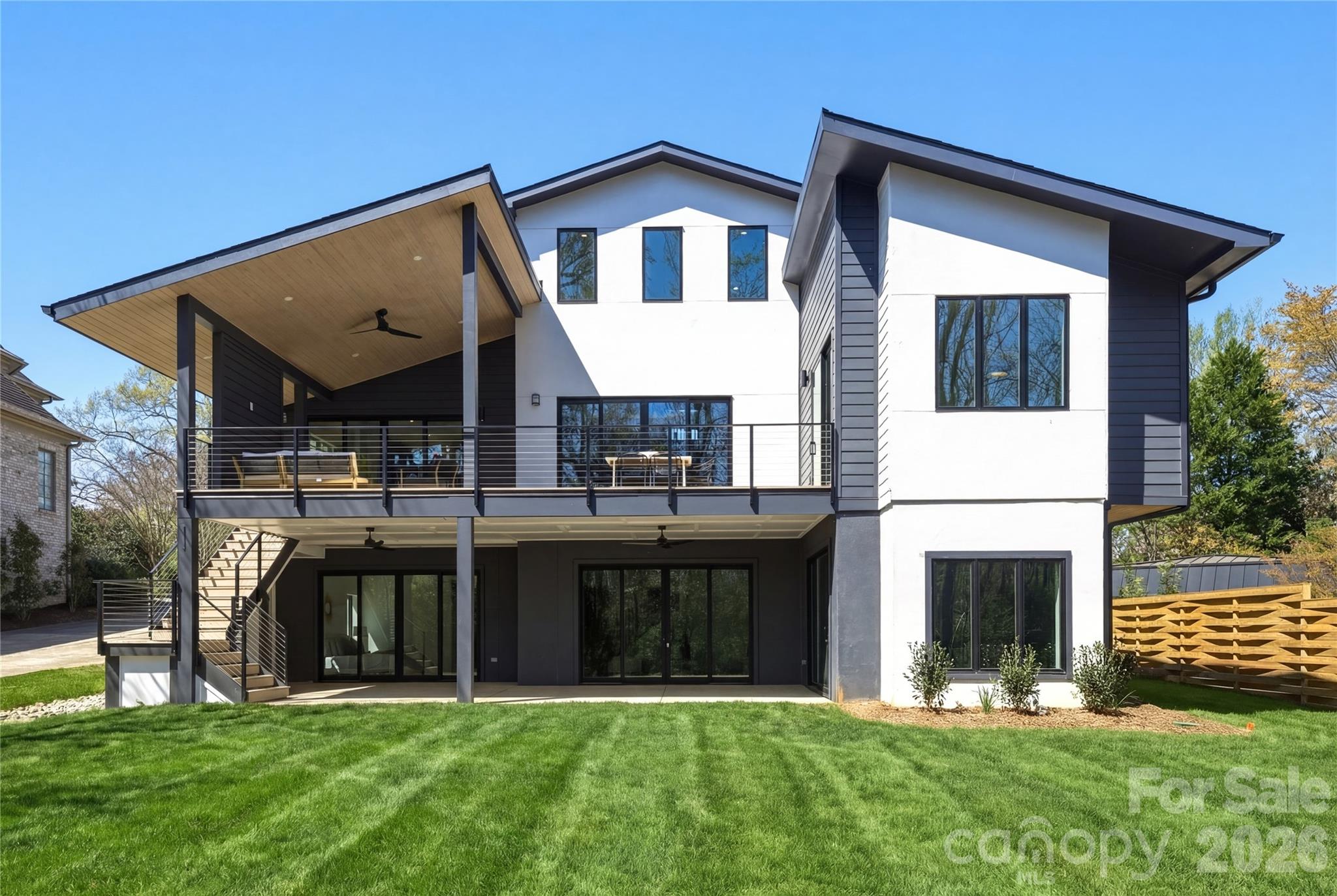 A fresh take on modern living, this stunning new home sits on an oversized lot with peaceful pond views in one of Charlotte’s most desirable neighborhoods. The setting offers a rare mix of privacy and space, with plenty of room to create your dream outdoor retreat. Designed to balance privacy with exceptional livability, the property offers generous outdoor space—perfectly suited for a future pool and a variety of entertaining possibilities.
Spanning approximately 5,500 square feet, the thoughtfully designed floor plan flows effortlessly, creating an inviting atmosphere ideal for both everyday living and hosting. Dramatic vaulted ceilings, premium appliances, a striking Isokern fireplace, and a dedicated wine cellar elevate the home’s modern sophistication. Outside you will enjoy multiple covered and open-air spaces that make indoor-outdoor living feel natural and easy—perfect for everything from quiet mornings to lively gatherings. All of this is set in an unbeatable in-town location, close to top schools, Uptown, great restaurants, shopping, and greenways. An optional elevator adds flexibility for the future, with the added possibility for future owners to access from Wrenwood Lane.