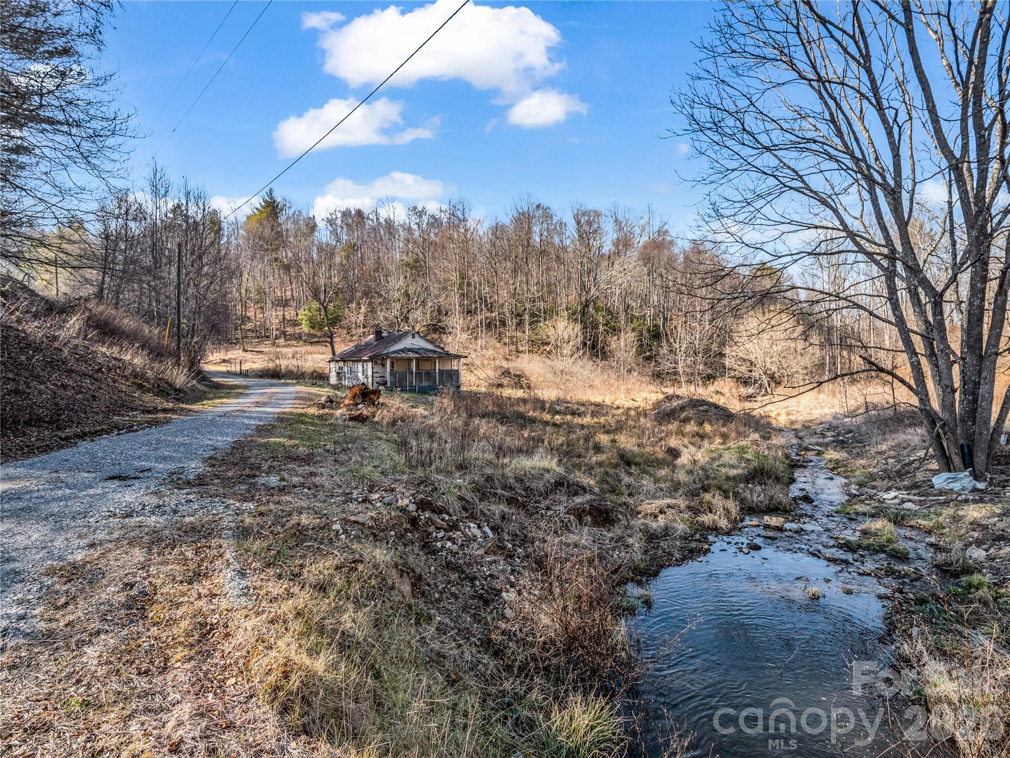 Discover your own private retreat on over 40 acres of unrestricted land in picturesque Bakersville. This expansive property features a sturdy metal barn and the historic shell of an old home, offering a unique opportunity to build your dream estate. Accessible via a shared, gated gravel driveway, the land provides both privacy and convenience. This is an estate property and no representation can be made. A potential well head has been located near the homesite, and all existing building materials are included, giving you a head start on your vision. Don't miss the chance to own a piece of serene country living, schedule your visit today