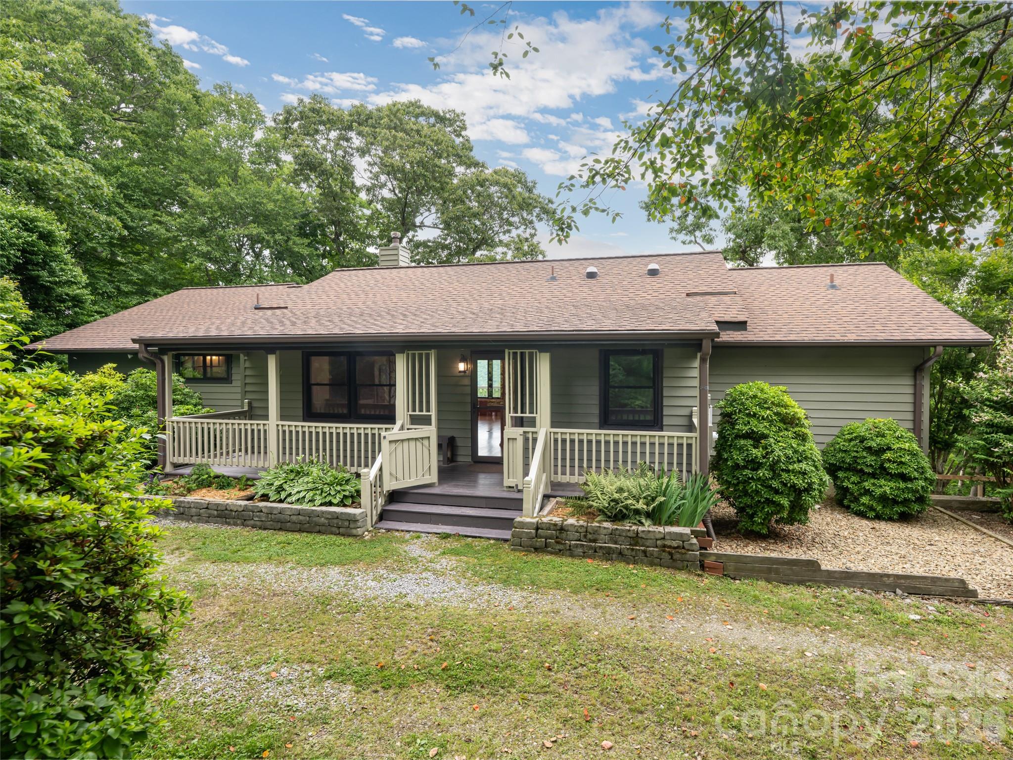 Exceptional 3 bed, 3 bath mountain retreat in Canton, NC. This private 1.69-acre knoll in The Glade community delivers ultimate privacy and serenity with breathtaking long and short-range mountain views. This home features two levels of living space. Main level includes an inviting great room complete with a Jotul wood stove, spacious kitchen with warm wood cabinetry, and access to expansive decks. Upper level also includes two en suite bedrooms. Downstairs you will find wonderful flexible space, a third bedroom and walk-out access. Large windows flood bright interiors with natural light and frame stunning views. Outdoor living excels on the covered front porch overlooking vibrant flower gardens and the large deck for relaxing in the peaceful wooded setting overlooking the mountains. Don't miss out on this wonderful opportunity complete with lots of owner upgrades.