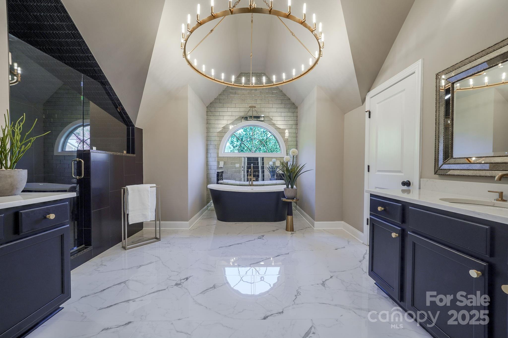 SOPHISTICATED ELEGANCE MEETS INVITING WARMTH ...Step into this PROFESSIONALLY decorated 5-bedroom, 4-bathroom home. The main level features a GUEST BEDROOM and FULL BATHROOM an office, and beautiful formal dining room boasting high-end lighting fixtures. The grand kitchen impresses with an OVERSIZED ISLAND, gas cooktop, wine bar, built-in ovens, quartz countertops and a seamless flow to the sophisticated GREAT-ROOM and SITTING AREA. Step outside from the sitting area to the SCREENED-IN PORCH and have a glass of wine while enjoying the sounds of nature.  Upstairs, the PRIMARY SUITE is a showpiece, offering a remodeled SPA-LIKE bathroom with freestanding tub, HEATED FLOORS, and luxury BRIZO fixtures. Dual custom closets with California closet systems (throughout home), art lighting a dressing area adds sophistication.  The second floor also includes a bonus room, laundry room, and 3 additional bedrooms and 2 full baths.  The third floor is already framed and plumbed for 2 more bedrooms, a full bath, and a bonus room-ready to be finished.  No lack of parking in the garages that offer 3 car spaces, epoxy flooring, custom cabinets, an organizing wall, and workspace.  The outdoor space is equally stunning, featuring a LARGE FENCED YARD, landscape lighting, an OUTDOOR KITCHEN with a gas line for the built in grill and stone fireplace sitting on a spacious patio-all overlooking a peaceful WOODED BACKDROP. This home perfectly blends luxury with comfort-like a page from Architectural Digest. Exceptional resort-style community amenities-pool, clubhouse, trails, tennis and pickleball courts sidewalks that lead to a variety of businesses including a butcher shop, bakery, coffee bar, dentist, drycleaners, vet office, salon, and fitness center.  Bridgemill is minutes from restaurants, Costco, Target and much more! Photos will be uploaded 10/24/2025