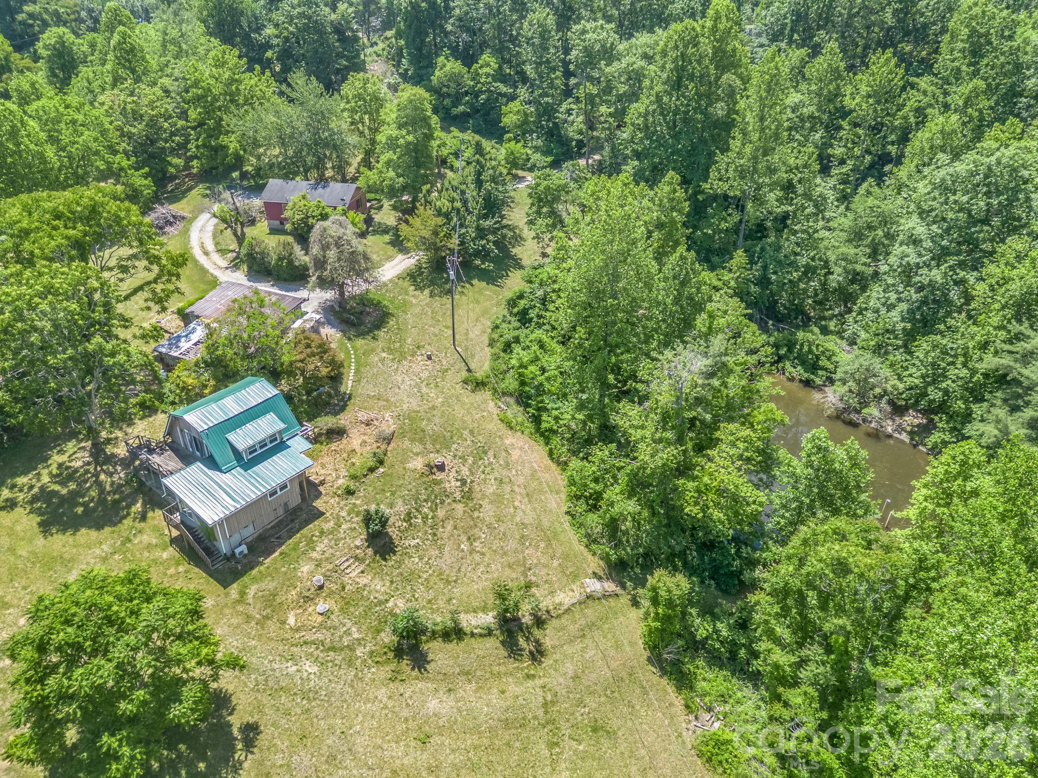 Nestled in the picturesque Blue Ridge Mountains just minutes from downtown Saluda, 255 & 257 Crescent Street present a rare opportunity to own a unique property with over 8 acres of gently rolling pastureland. Located less than one mile from Main Street, this versatile property features two homes, a pond, a garage with attached shed, and expansive open space with a variety of potential uses. Property is zoned Multiple Use.

Now offered at an improved price, this property presents exceptional value for buyers seeking acreage, flexibility, and the opportunity to create something truly special in one of Western North Carolina's most charming mountain towns.

The brown home offers approximately 3 bedrooms and 3 bathrooms with distinctive wood architectural details, a loft area, and a spacious floor plan full of character and ready for renovation or updates to suit your vision. The red home is a 2-bedroom, 2-bath residence featuring hardwood floors and an open-concept layout, providing a solid foundation for continued enjoyment or future improvements.

The property offers a unique blend of usable acreage, multiple dwellings, and a highly desirable location. The pond creates a peaceful focal point, though restoration work may be needed to maximize its potential. While the homes and grounds would benefit from repairs and updates, the possibilities are plentiful for those seeking a property with character, space, and significant upside potential.

Whether you're looking for a private retreat, hobby farm, investment opportunity, family compound, or a property to renovate and make your own, this offering provides a rare combination of acreage, versatility, and location. Conveniently located near local shops, restaurants, outdoor recreation, and area attractions, this is an exceptional opportunity to reimagine and restore a unique Saluda property.