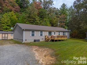 Peaceful mountain living calls from this beautiful three bedroom, two bath home. Situated on a large lot, with a level yard, you'll love taking in the stunning mountain views from the oversized front porch. Inside, you’ll find generously sized rooms throughout, including a bright, open kitchen, two living rooms and a large primary suite with a private en-suite bath. The flat yard provides plenty of room for pets, play, or gardening, making it ideal for outdoor living. Enjoy the private setting while being just minutes from downtown Sylva and Cherokee, offering easy access to schools, shopping, and local dining. Whether you’re searching for a primary residence, vacation home, or investment property, this home checks all the boxes for the best of mountain living.
