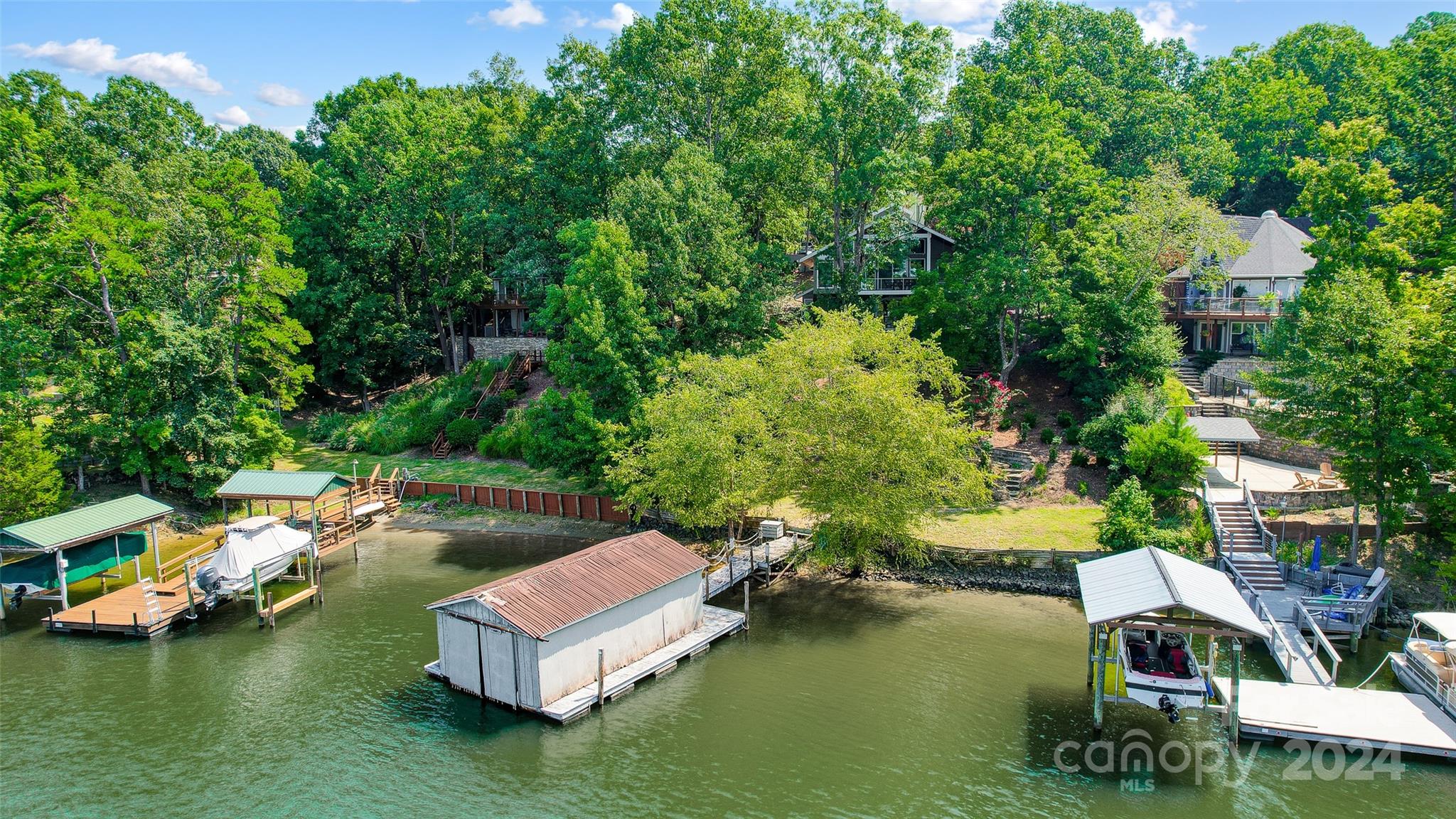 Discover your waterfront oasis in this stunning custom home. Spend leisurely days relaxing on the covered balcony or entertaining guests on the expansive covered patio, complete with an outdoor kitchen and hot tub. Your private boathouse with lift is the perfect complement to a day of boating or fishing. Inside, a modern open floor plan creates a seamless flow between the gourmet kitchen, featuring stainless steel appliances, and the spacious great room filled with natural light. Wake up to breathtaking lake views from the comfort of your main floor primary suite.  Upstairs, a versatile loft offers endless possibilities and lake views. The lower level is an entertainer's dream with a large rec room, additional bedrooms, and ample storage. Immerse yourself in the vibrant Tega Cay lifestyle, offering golf, tennis, swimming, and outdoor recreation. Enjoy top-rated Fort Mill schools and the benefits of South Carolina taxes.  This is more than a home; it's a lifestyle.