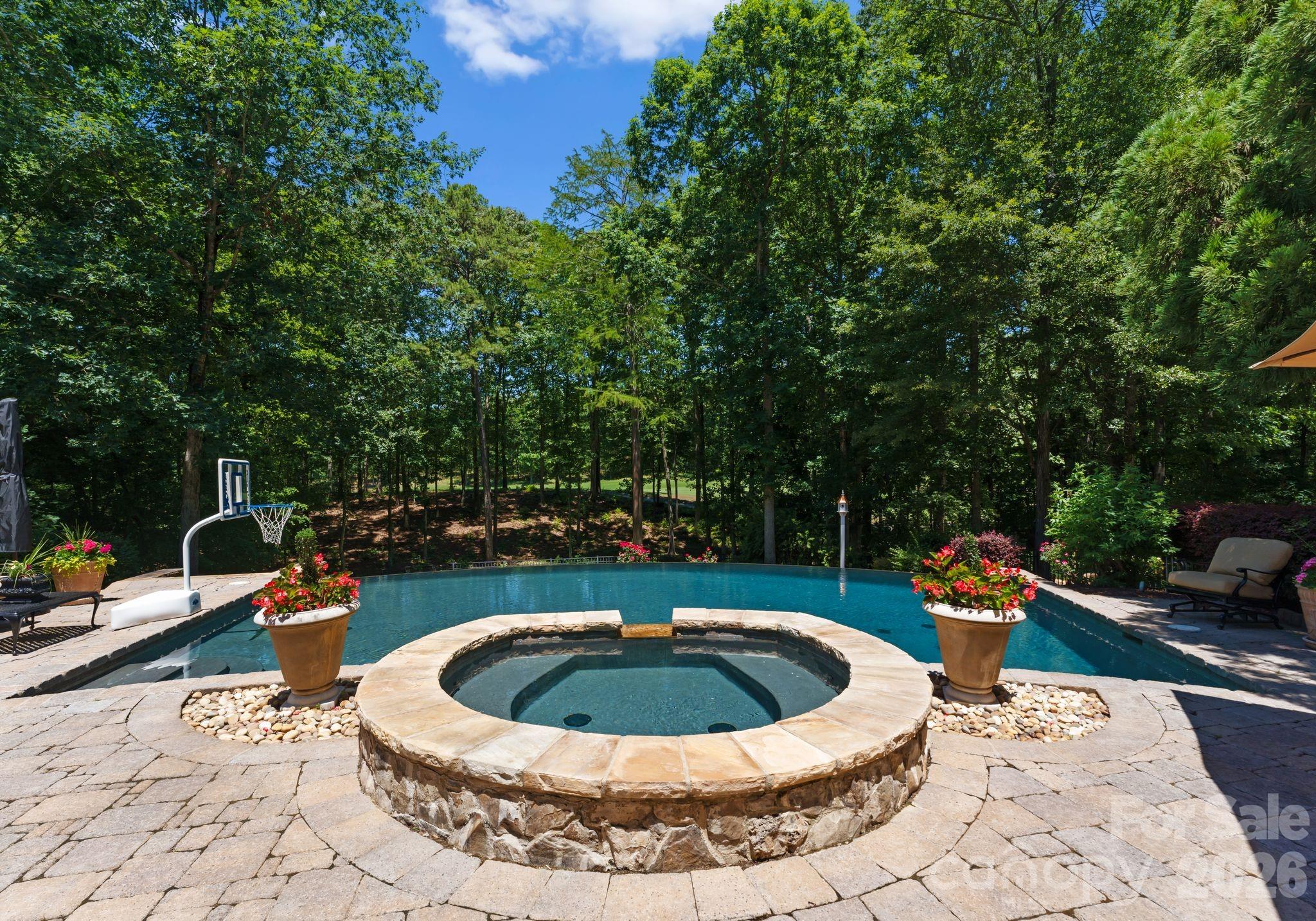 This custom estate embodies luxury, privacy, and timeless elegance. Positioned to overlook the first hole of the prestigious Jack Nicklaus–designed golf course, this residence offers breathtaking views and an unmatched setting for elevated living. A grand glass view elevator seamlessly connects each level, while the study is anchored by a striking cast stone fireplace. The wine room, adorned with exquisite stonework, is ideal for curated tastings and intimate gatherings. Three expansive terraces create a seamless indoor–outdoor experience, leading to a resort-style infinity-edge saltwater pool.  Sight unseen owners entry, where you can enter through the lower-level garage, enjoy the spa-like amenities, then continue up to the primary corridor, offering a refined sense of arrival and effortless flow throughout the home. Every detail of this home reflects elevated living, where elegance and function converge to create a lifestyle without parallel.