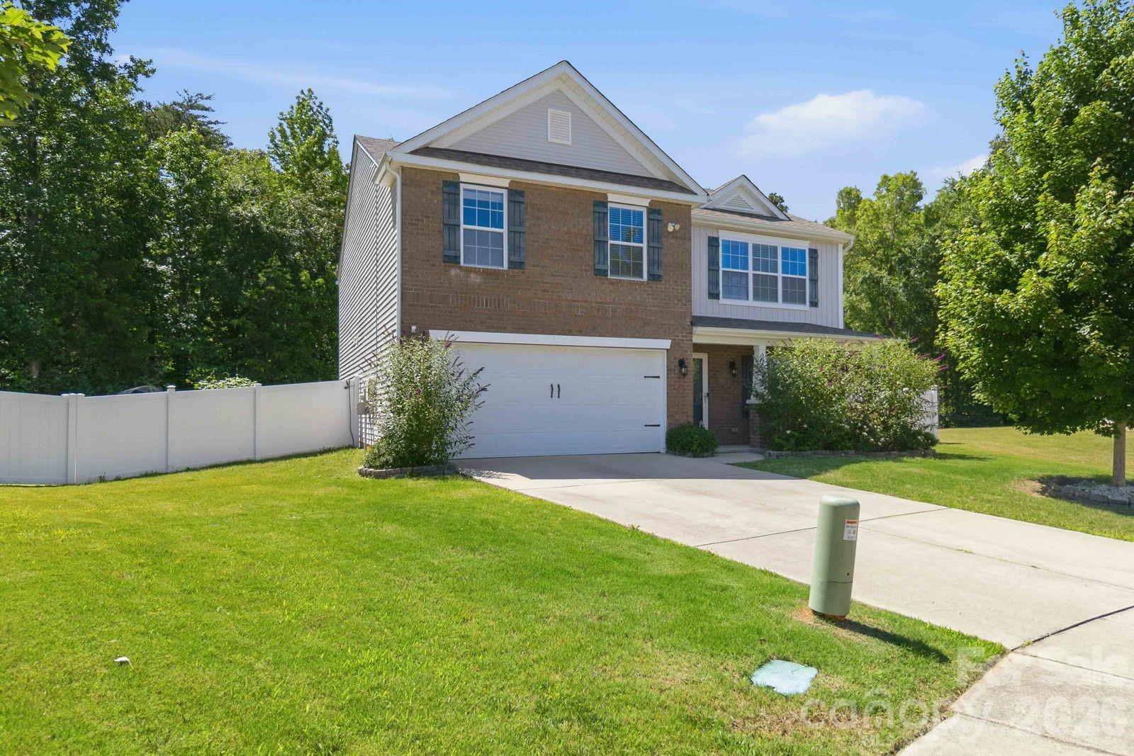 Situated on an extra-large cul-de-sac lot, this exceptional home offers privacy, space, and energy efficiency. The privacy fenced backyard backs to a natural area, creating a peaceful setting perfect for relaxing or entertaining on the expansive rear patio and large paver patio with fire pit. A charming rocking chair front porch, shaded by mature butterfly trees, welcomes you home. The beautifully updated kitchen features granite countertops, abundant cabinet and countertop space, a pantry, white-faced Samsung appliances, and a bar-top that opens to the spacious family room with a gas log fireplace. The main level also offers a bright breakfast area, large dining room, and a guest bedroom with a full bath. Upstairs, the oversized primary suite provides a luxurious retreat with dual vanities, separate tub and shower, and an impressive custom walk-in closet with built-ins. Three additional bedrooms, all with walk-in closets and ceiling fans, share a spacious full bath with dual vanities. A large laundry room adds convenience. Enjoy the benefits of fully paid-for solar panels participating in Duke Energy's Net Metering Program, helping offset utility costs while providing energy efficiency. The community amenities include a neighborhood pool and playground. Combining privacy, functionality, outdoor living, and modern efficiency, this home offers an outstanding lifestyle opportunity.