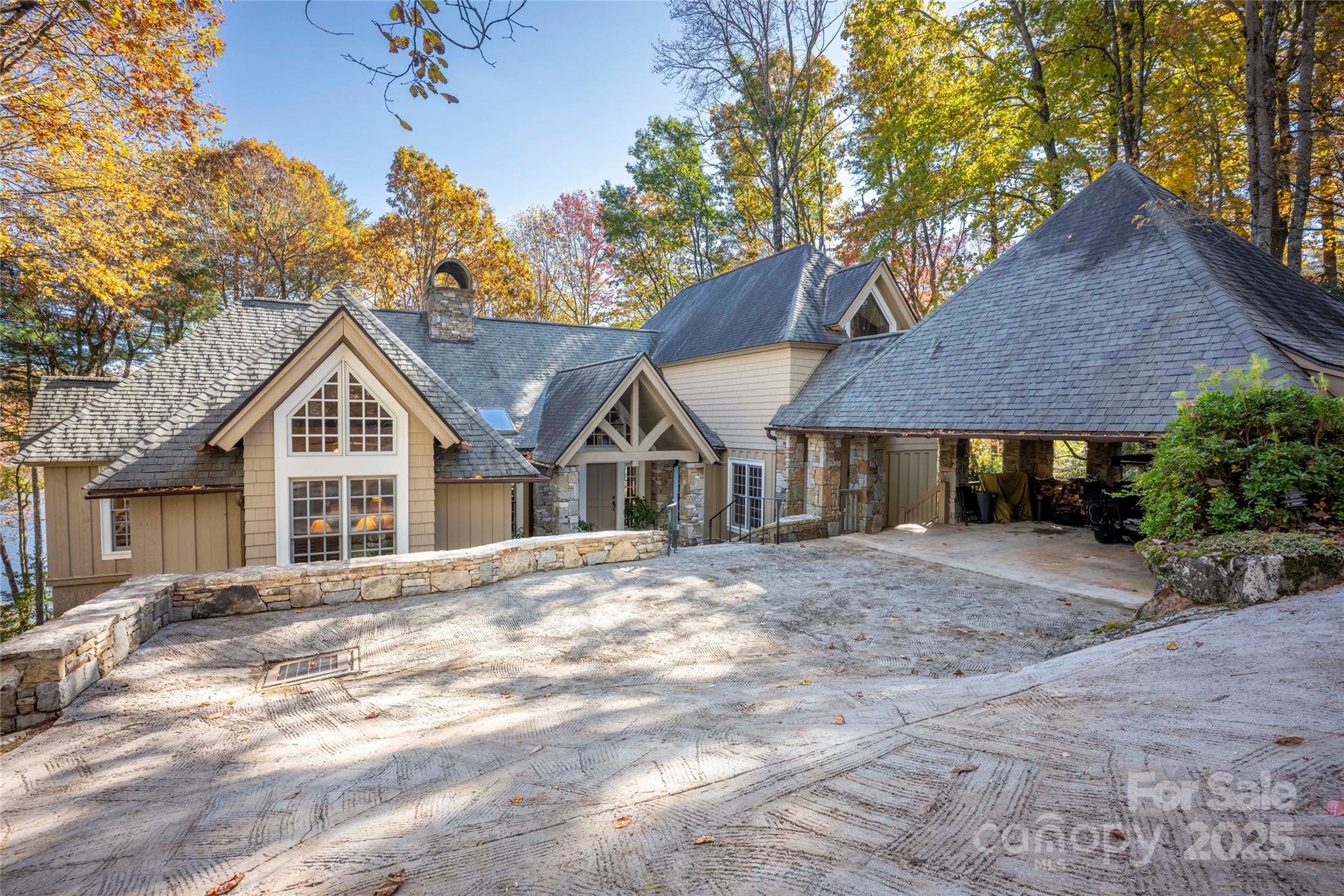 Nestled on Red Bird Circle, one of Lake Toxaway’s truly special locations, this exceptional lakefront residence reflects the timeless style and craftsmanship of architect Tim Green. Thoughtfully positioned to face east, the home captures beautiful sunrises and long-range lake views from nearly every room.
With 150 feet of prime lake frontage, the property offers both privacy and an intimate connection to the water. Inside, soaring ceilings and rich wood paneling create a warm, inviting atmosphere that blends mountain character with refined sophistication. The Rumford fireplace serves as the home’s centerpiece, offering both architectural presence and cozy comfort.
The chef’s kitchen pairs modern functionality with rustic charm — a relaxed, beautifully designed space ideal for cooking and gathering. Throughout the home, thoughtful details foster an easy flow between indoor and outdoor living.
It’s a rare opportunity to own a signature Lake Toxaway residence in a coveted setting, where classic design and lakefront living come together effortlessly. Membership to Lake Toxaway Country club is based on application and availability.