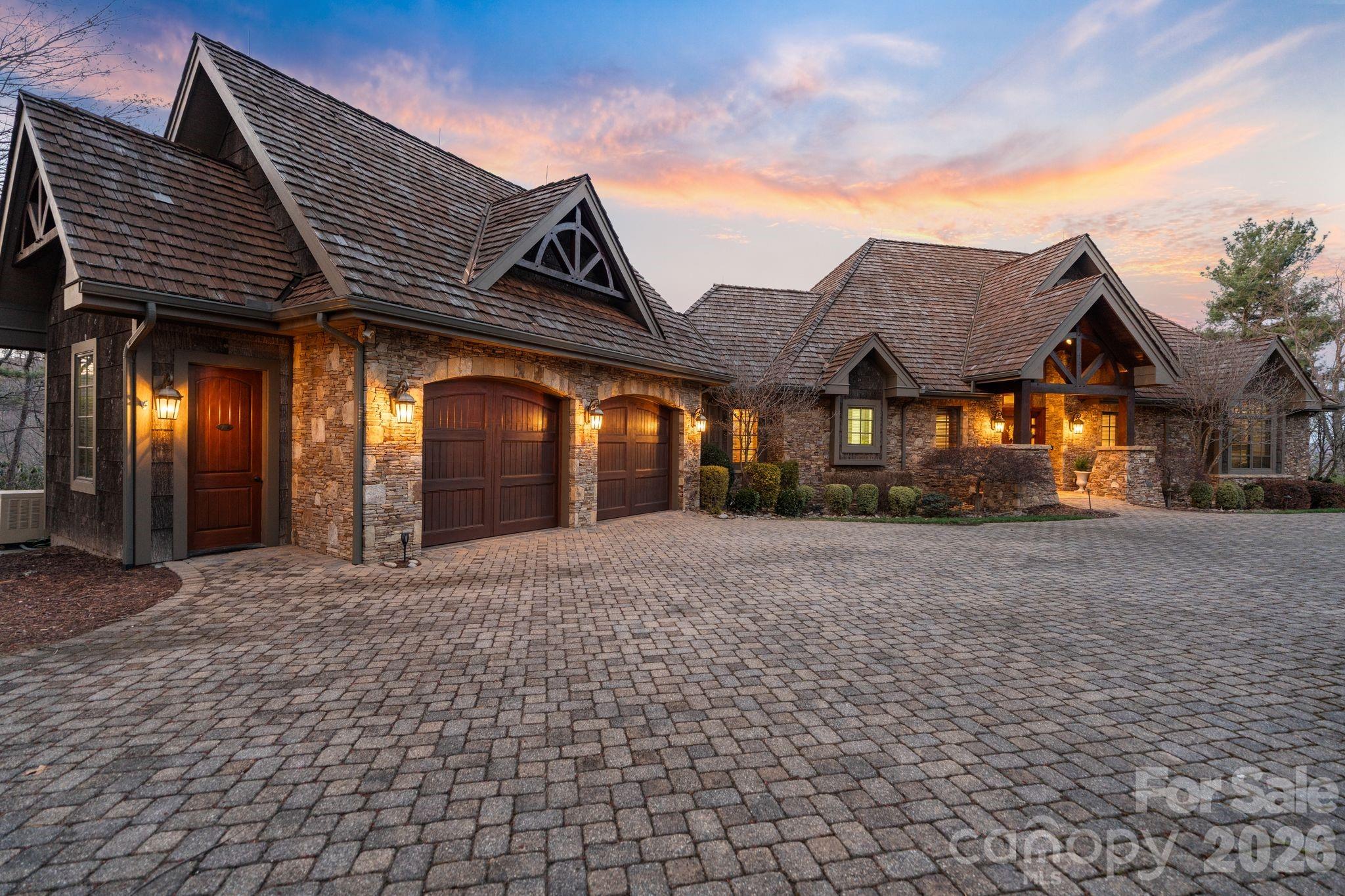 Perched high within Blue Ridge Mountain Club, this extraordinary mountain estate at 2054 Reynolds Parkway redefines mountain living. Spanning over 7,400 square feet, this architectural masterpiece captures breathtaking long-range mountain views while blending timeless craftsmanship with elevated modern luxury.
Designed for both grand-scale entertaining and intimate retreat, the residence offers 5 spacious bedrooms, 5 full baths, and 2 half baths, with a luxurious primary suite thoughtfully positioned on the main level. From the moment you arrive by way of the cobblestone driveway, the attention to detail is unmistakable. Inside, soaring tongue-and-groove ceilings anchor the dramatic living room, while hardwood floors flow seamlessly throughout the home. Five fireplaces create warmth and ambiance across multiple living spaces.
The chef’s kitchen is a true showpiece, appointed with premium appliances, custom cabinetry, natural stone finishes, and effortless connecting to the expansive covered deck featuring a built-in grilling station and abundant outdoor entertaining space. Multiple levels of outdoor living invite you to experience the serenity of the mountains year-round.
Curated for luxury living, the lower level boasts a sophisticated entertainment lounge, wet bars on both levels, stunning stone-walled wine cellar and a state-of-the-art theater with a high-end electronic package. The sellers have also recently installed a state-of-the-art whole-house Lutron smart system, offering seamless control of lighting, ambiance, and comfort throughout the residence. Natural cedar and bark siding blend seamlessly into the surrounding landscape, creating an authentic mountain-lodge aesthetic without compromising sophistication. Additional premium features include an elevator, standby generator, and exceptional craftsmanship throughout.
Residents of Blue Ridge Mountain Club enjoy an unparalleled lifestyle with gated security and world-class amenities including a Ascent Wellness and fitness center, resort-style pool, pickleball courts and a restaurant (Lookout Grill.) and over 50 miles of ATV trails, walking and hiking trails.  BRMC provides endless opportunities to experience the beauty of the Blue Ridge Mountains.
A rare offering where luxury, privacy, and mountain elegance converge.

Check out Blueridgemountainclub.com for more info on the community! 

Home is sold fully furnished with accepted offer.  Seller intends to keep tree in living room and a few other small items.
