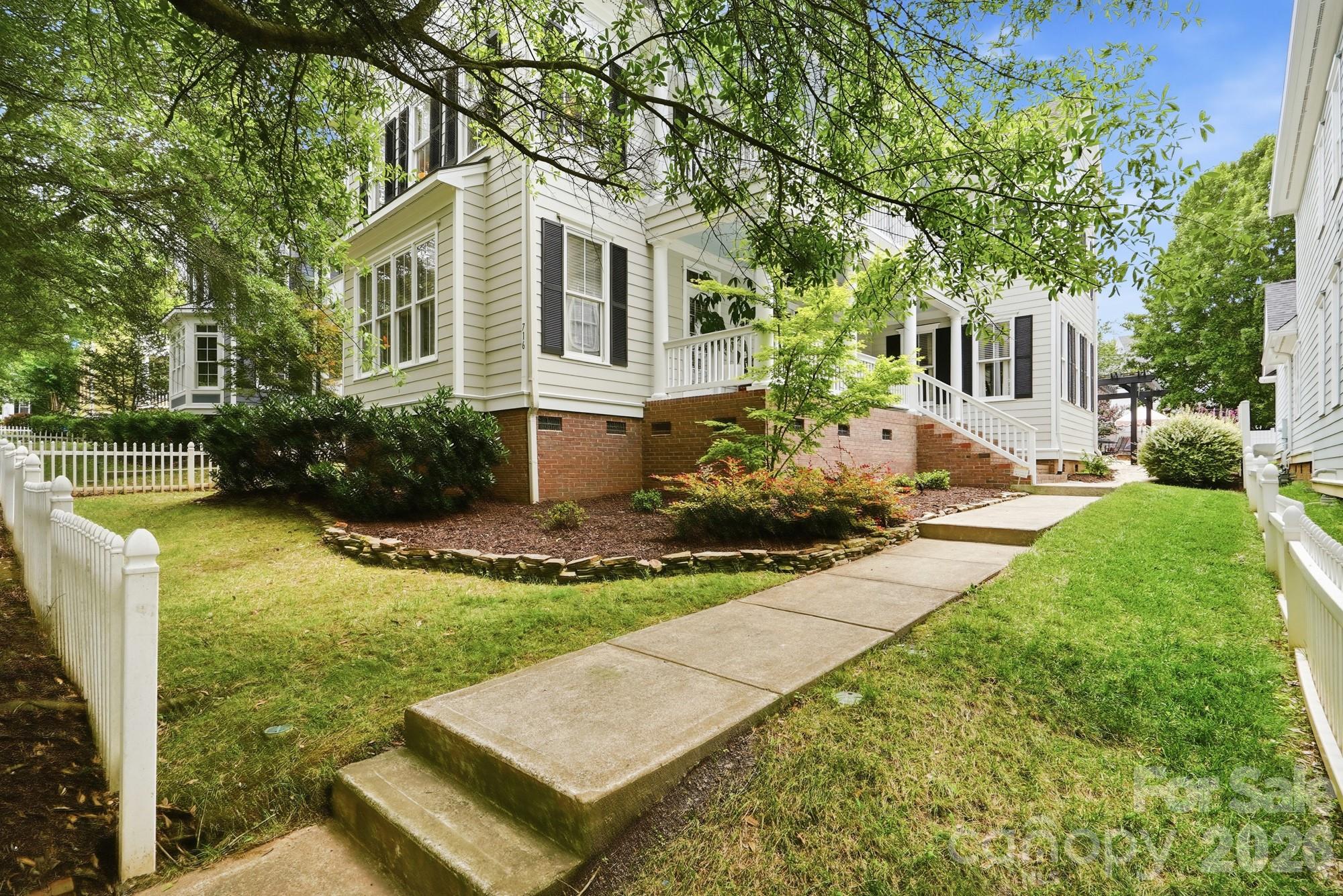Beautifully updated Charleston-style home with double front porches in the heart of Baxter Village! Perfectly situated just steps from vibrant Market Street, this exceptional home offers the ideal blend of timeless Southern charm and modern updates in one of Fort Mill's most sought-after communities. Inside, you'll find a bright, open floor plan filled with natural light, rich hardwood floors, designer finishes, and thoughtfully updated spaces throughout. The gourmet kitchen features quartz countertops, upgraded stainless steel appliances, stylish backsplashes, a pantry, and opens seamlessly to the breakfast area and spacious great room with a cozy gas fireplace, perfect for entertaining or everyday living. The main-level primary suite provides a private retreat with a beautifully appointed bath, while the upper level offers generously sized secondary bedrooms, multiple baths, and flexible living space ideal for a home office, bonus room, a second primary suite or guest accommodations. Relax on one of the two expansive front porches, or unwind on the side porch and private patio surrounded by mature landscaping. Beyond your front door, you'll love being just a short walk to Market Street's restaurants, coffee shops, boutiques, fitness studios, the Fort Mill Library, parks, and year-round community events. Baxter Village residents also enjoy resort-style amenities including pools, tennis courts, playgrounds, walking trails, clubhouse, and recreation areas. This is more than a beautiful home, it's a lifestyle. Experience walkable living, award-winning Fort Mill schools, and everything that makes Baxter Village one of the Carolinas' most beloved communities.