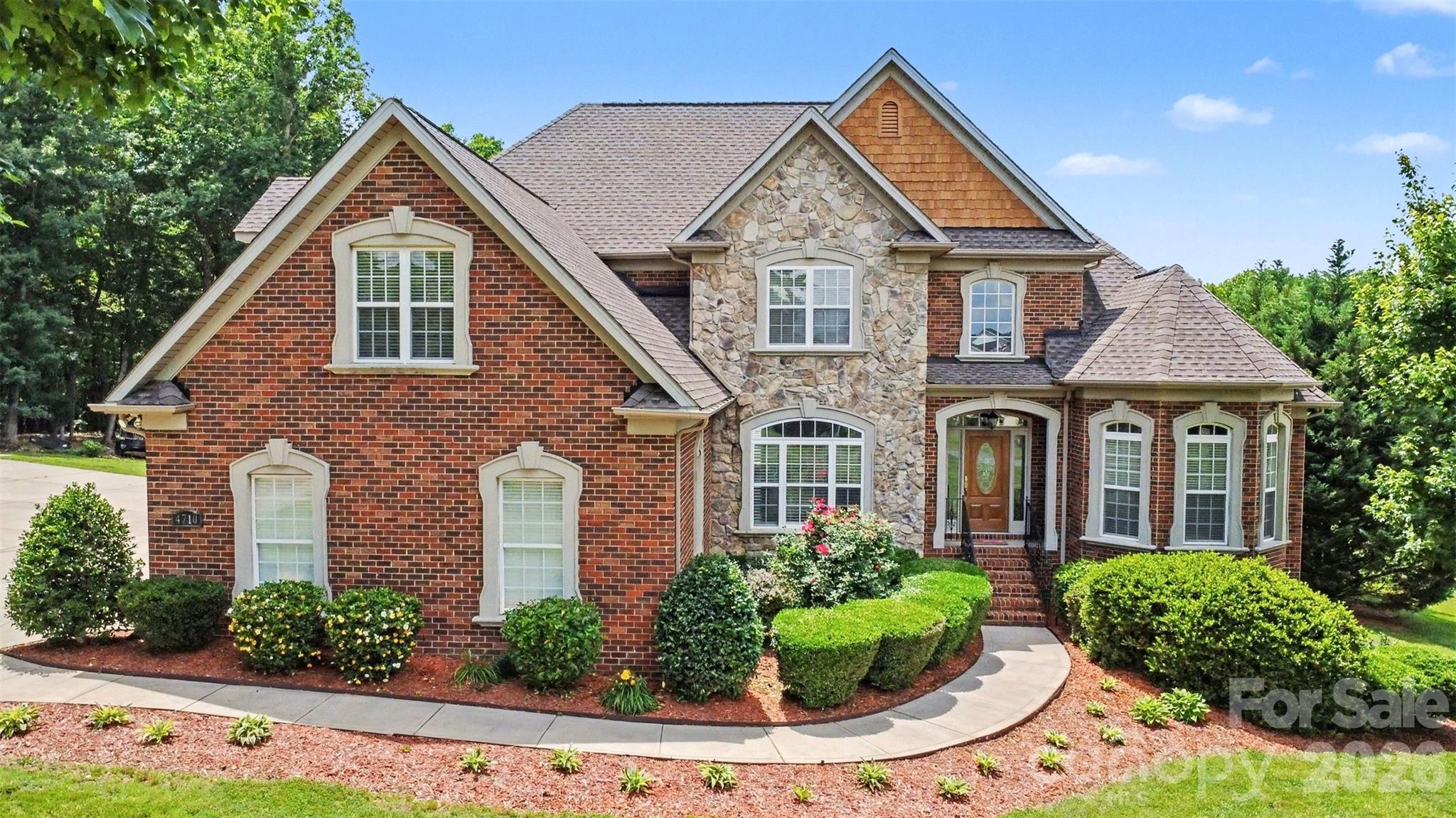 Welcome to an exceptional brick home tucked away on a beautifully landscaped homesite in the highly sought-after Queens Gate community of Waxhaw. Surrounded by mature trees and offering an impressive combination of privacy, space, and resort-style outdoor living, this property delivers the lifestyle today's buyers are searching for.
Inside, soaring ceilings and abundant natural light create a warm yet elegant atmosphere. The spacious great room features a dramatic two-story ceiling and fireplace, flowing seamlessly into the expansive kitchen. Thoughtfully designed for both everyday living and entertaining, the home offers generous gathering spaces including a formal dining room and a breakfast nook right off the kitchen. The main-level also boasts a desirable primary suite as well as a secondary bedroom.
The primary retreat is a true sanctuary, complete with a tray ceiling, spa-inspired bathroom with a jetted tub, separate shower, and oversized walk-in closet. Upstairs, two more spacious secondary bedrooms and a large bonus room provide flexibility for recreation, media, fitness, or work-from-home needs.
One of the home's standout features is the incredible outdoor setting. An enclosed three-season room overlooks the private backyard and sparkling in-ground pool, creating the perfect backdrop for relaxing evenings, weekend gatherings, and summer entertaining. The expansive yard offers room to play, garden, or simply enjoy the peaceful wooded surroundings. Car enthusiasts, hobbyists, and those needing additional storage will appreciate the rare garage capacity, including both a 3-car attached garage and 3-car detached garage space.
Queens Gate is known for its spacious homesites, mature landscaping, and quiet residential atmosphere while remaining conveniently located near all that Waxhaw has to offer. Residents enjoy easy access to charming downtown Waxhaw's shops, restaurants, breweries, and year-round community events. Commuters benefit from convenient access to Ballantyne, Waverly, Rea Farms, and Uptown Charlotte, shopping, dining, and everyday conveniences are just minutes away.
Offering timeless curb appeal, exceptional indoor and outdoor living spaces, and an unbeatable Waxhaw location, this is a rare opportunity to own a truly special property.