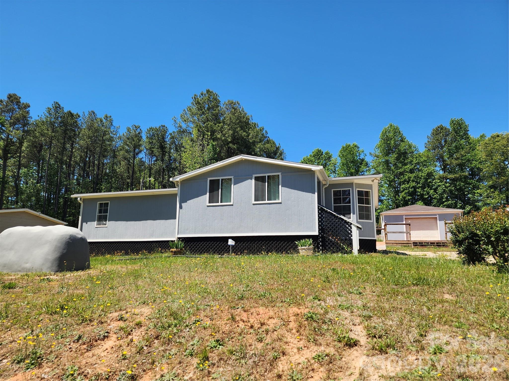This charming, manufactured home offers a peaceful, comfortable place to call home. With a welcoming layout and well-kept interior, it’s perfect for anyone wanting simple, affordable living without sacrificing comfort. The Open front room is perfect for relaxing. It offers a large functional kitchen with ample counter space and Comfortable bedrooms. The home invites you with a nice array of amenities and inclusions. Check out the rain soft water system, newer jacuzzi tub at the master, newer roof, gutter guards, newer HVAC system and many outbuildings to keep you organized. This home is a dream come true.
