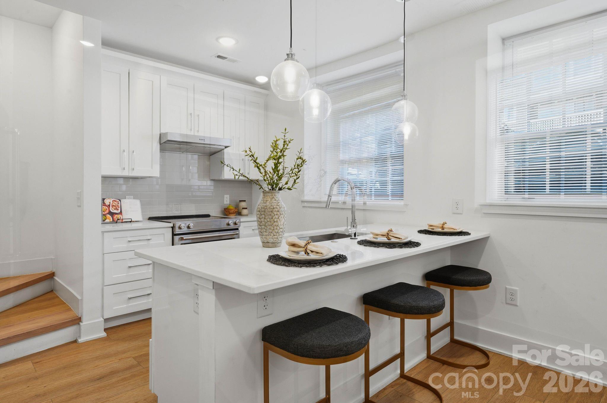 A rare opportunity to own a piece of Charlotte history — thoughtfully reimagined for modern, lock-and-leave living. Located within The Arches, a boutique collection of residences set inside a restored 1927 church in the heart of Wesley Heights, this luxury townhome-style condo offers a distinctive blend of historic architecture, modern functionality, and urban convenience. Originally built as a neighborhood church and place of gathering, the building has been carefully transformed while preserving its historic integrity, timeless presence, and architectural character. Each residence offers a private entrance, giving the home a sense of individuality and privacy rarely found in condo living. Inside, the main living area feels bright, open, and inviting, with warm wood flooring, fresh neutral interiors, recessed lighting, modern ceiling fans, and abundant natural light. The open-concept layout flows seamlessly from the living area into the kitchen, creating an easy everyday living and entertaining experience. The kitchen is beautifully appointed with white cabinetry, quartz countertops, stainless steel appliances, a tile backsplash, pendant lighting, and an oversized island with seating. Spa-inspired baths feature porcelain tile shower walls and floors, modern fixtures, and clean, elevated finishes. The private rooftop terrace is one of the home’s standout features, offering the perfect place to unwind, entertain, and take in Uptown Charlotte views and evening city lights. Additional highlights include an assigned on-site parking space deeded with the unit, thoughtful modern finishes throughout, and the unique character of a historic adaptive reuse property. Ideally located minutes from Uptown Charlotte, South End, I-77, greenway access, parks, breweries, coffee shops, restaurants, and neighborhood favorites throughout Wesley Heights, The Arches offers a rare blend of history, design, and lifestyle in one of Charlotte’s most connected urban neighborhoods.
