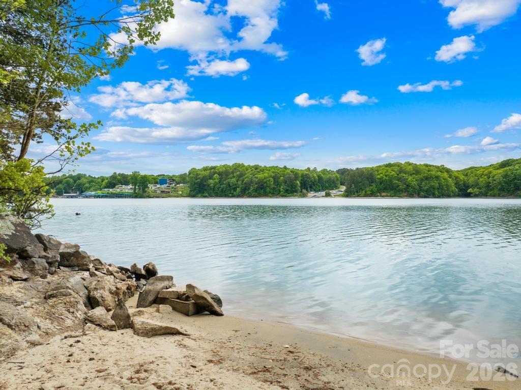 Discover an extraordinary opportunity to create an estate in the prestigious gated Harbor Watch community on Lake Norman. Positioned at the end of a quiet cul-de-sac, this exceptional .81-acre waterfront homesite offers approximately 189 feet of shoreline along the main channel, delivering expansive water views and an unmatched sense of privacy. The sloping topography is ideal for a walk-out basement design, allowing you to fully capture the beauty of the lake while seamlessly blending indoor and outdoor living. With no time limit to build, you have the freedom to bring your own builder and craft a custom home with no timeline. Based on a recent soil evaluation, Lots 27 (272 S Harbor Watch Dr.- MLS #4375705) and 28 are being marketed together to create a 3-4 bedroom estate, resulting in an impressive 1.53 acres and approximately 363 feet of shoreline- an almost unheard-of footprint on Lake Norman. Surrounded by natural beauty and within one of the area’s most desirable gated communities, this property offers the perfect balance of seclusion, luxury, and lifestyle. Experience the serenity of waterfront living while remaining just moments from everything Lake Norman has to offer.  Harbor Watch offers a boat storage lot, community boat launch and day docks, picnic area, and catch and release stocked ponds.