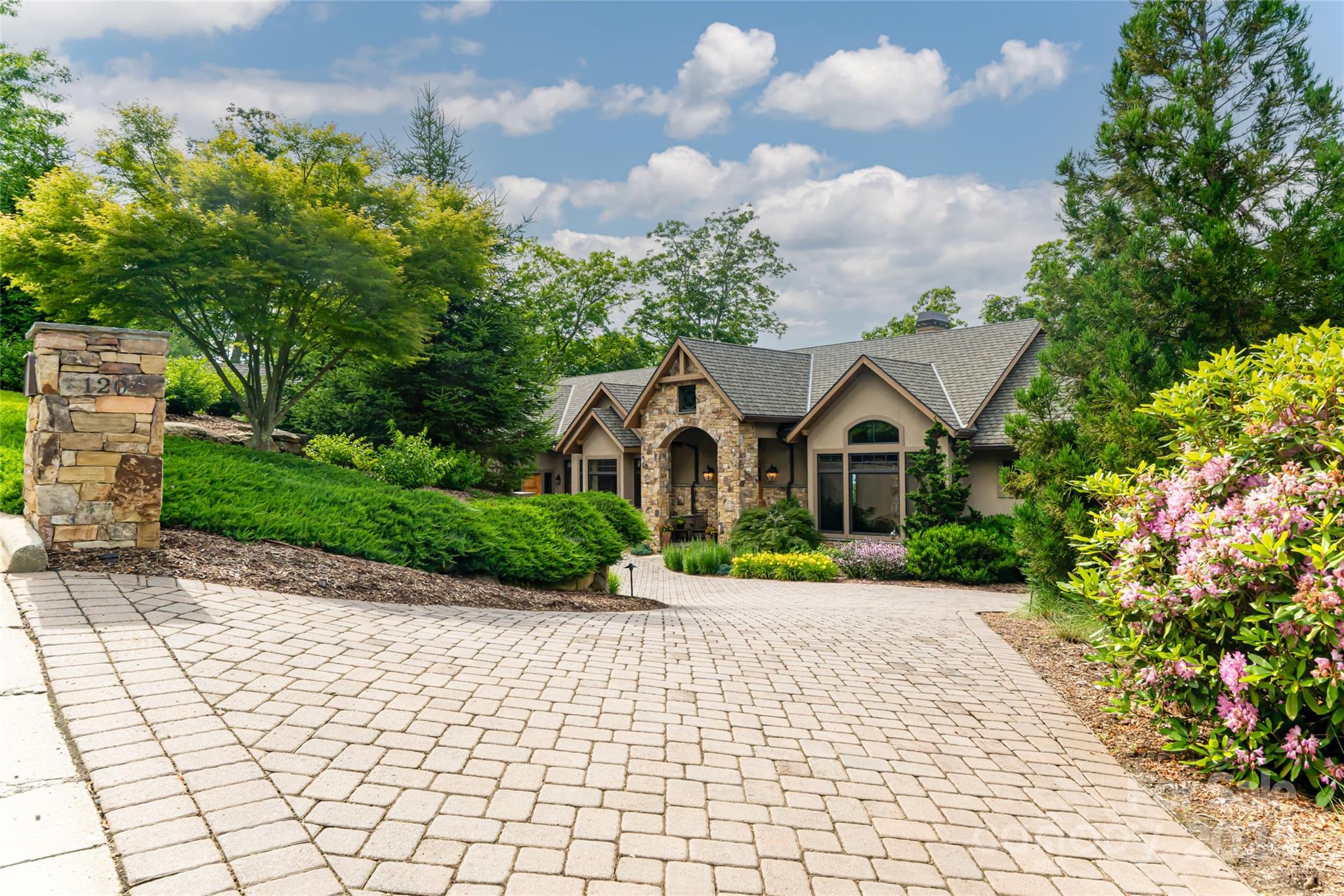 Discover the essence of luxury living in this stunning custom-built Morgan-Keefe home in Asheville's prestigious Reynolds Mountain community. This contemporary Arts and Crafts residence offers long-range mountain views and combines elegance with modern comforts. The home features four spacious bedrooms, each with its own ensuite bathroom, and two offices, ideal for working from home. The custom-designed kitchen is equipped with top-of-the-line appliances, perfect for culinary enthusiasts. The property boasts two great rooms on each level featuring custom leathered marble fireplaces. The primary suite includes a private screened-in porch, a lavish oversized shower, and a soaking tub. Outdoor living is enhanced by expansive porches with a stone fireplace, perfect for entertaining or relaxing while enjoying breathtaking mountain scenery. Energy efficiency is ensured with a geothermal heating system. Additional amenities include a three-car garage with extensive storage space.