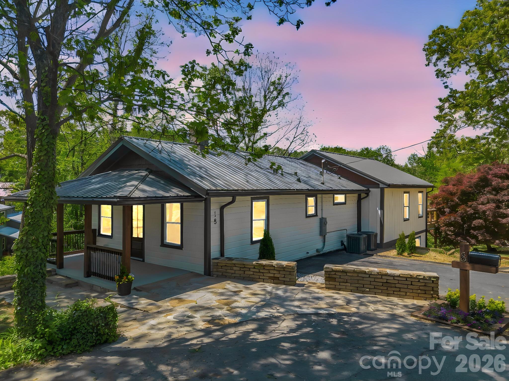 Thoughtfully reimagined West Asheville bungalow with soul, craftsmanship, and everyday ease. This beautifully renovated 4-bedroom, 3-bath home offers 2,566 square feet of warm, intentional living space in one of Asheville’s most beloved neighborhoods. Inside and out, the home blends character with meaningful updates buyers rarely find in one place. A highly functional layout offers the convenience of main-level living, featuring the primary suite with en suite bath, a second bedroom, with a 2nd full bath, and laundry all on the main floor. The primary suite feels like a true spa-inspired retreat, with its en suite bath featuring a dual overhead rain shower and handheld wand. French doors from both the kitchen and primary suite open to a brand-new deck, perfect for morning coffee, evening conversation, and quiet mountain air. Behind the charm is a full-scale systems overhaul, including all new plumbing and electrical, dual-zone HVAC, new roof and gutters, newly installed French drains, and a new retaining wall at the basement entry, offering lasting quality and peace of mind. Inside, new oak flooring on the main level and Rockwool insulation in the walls add comfort, sound dampening, and energy efficiency. The versatile lower level includes a full bath, private entry, generous living area, and two additional bedrooms, creating flexible space for guests, a studio, creative retreat, extended family, long term rental, or simply room to spread out. The spacious 0.29-acre lot, larger and more usable than many in the neighborhood, offers room for gardens, gathering spaces, additional parking, or a future shed. Just minutes from Haywood Road shops, coffee, restaurants, music venues, and local boutiques, this home captures the creative, connected spirit that makes West Asheville so special.