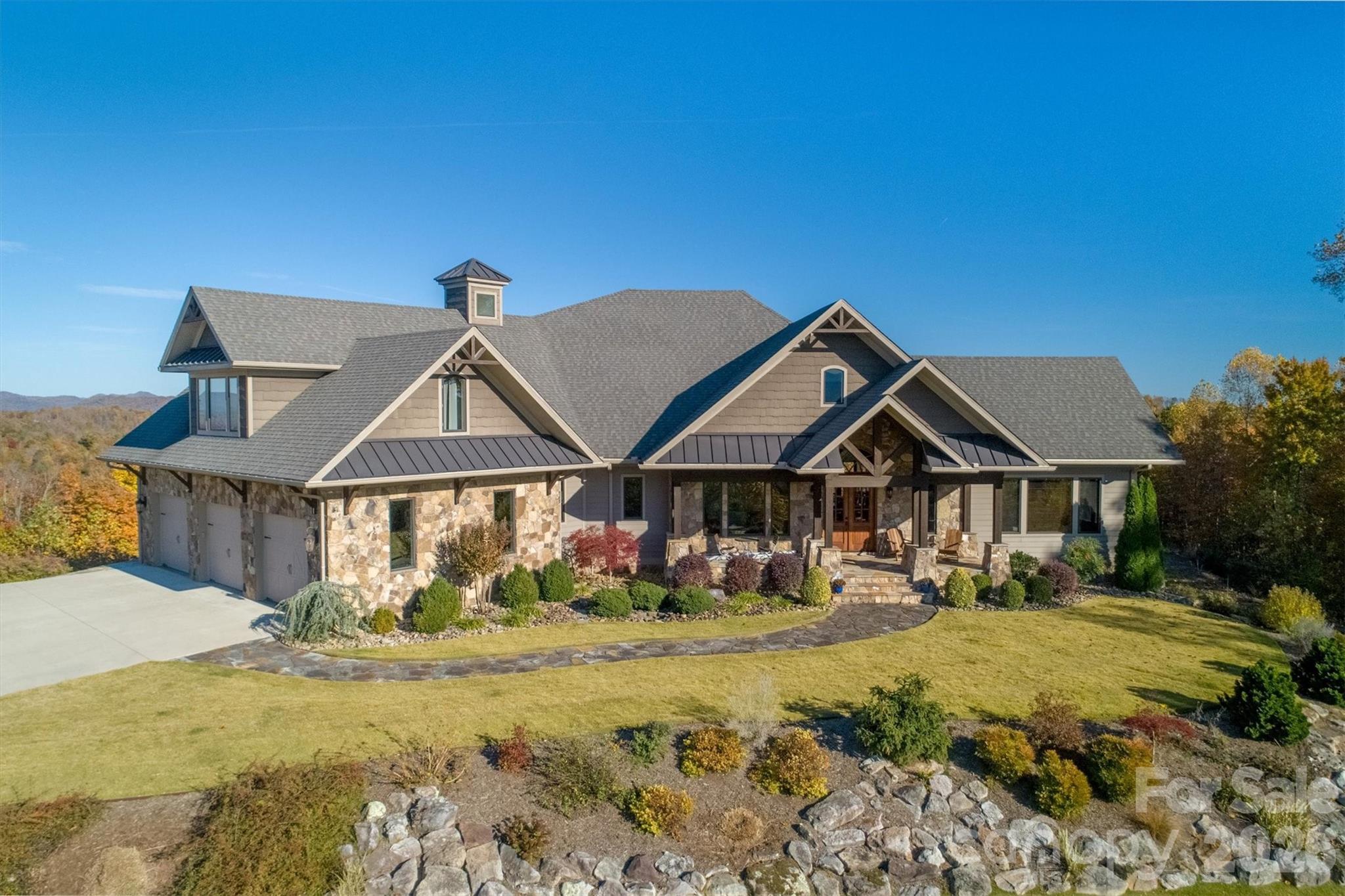 Nestled on 10.15 private acres in the highly sought-after gated community of The Coves Mountain River Club, this exceptional 6,300± sf custom home offers space, versatility, and refined mountain living with uninterrupted long-range views of the Blue Ridge Mountains. Built with 2x6 construction and thoughtfully designed throughout, the home features 4 bedrooms, ***2 bonus rooms***, and 4 full baths.

The main level (2,700± sf) showcases oak flooring, a spacious living room, and a cozy keeping room with a stunning stone fireplace. The well-appointed kitchen features cherry cabinetry, a walk-in pantry, and flows seamlessly for everyday living and entertaining. The primary suite offers a private retreat with ensuite bath, complemented by a bonus room, full bath, and laundry.

Upstairs (900± sf) is a private 2-bedroom apartment with living area, kitchenette, full bath, and walk-in attic—ideal for guests or multi-generational living. The lower level (2,700± sf) offers a large recreation room with wet bar, guest bedroom, sewing room, full bath, workshop, and UTV/storage space.

Additional highlights include a 3-car garage with EV charger, whole house generator, wired security system, central vacuum, water reclamation system, and a detached art studio with mini-split.

Located just 75 minutes from Charlotte Douglas International Airport, The Coves is a designated dark sky community, preserving the natural beauty of the night sky with minimal light pollution, perfect for stargazing and enjoying peaceful, serene evenings. This rare offering combines acreage, privacy, breathtaking views, and luxury within one of Western North Carolina’s premier mountain communities.