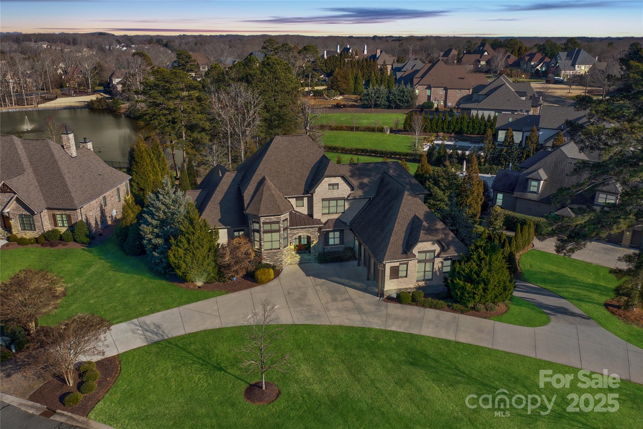 This Providence Downs South estate epitomizes sophistication on .93 acre private lot overlooking a tranquil pond. 2-story foyer welcomes you with soaring ceilings and refined details, setting the tone for the entire home. The oversized kitchen features double islands, perfect for hosting gatherings of any size.  The main level primary includes 2 custom closets, coffee bar, and a spa-like bathroom with dual water closets and soaking tub.  Upper level boasts 4 spacious bedrooms with en-suite baths. Basement features multiple recreation areas, movie room, full kitchen, additional guest bedroom and pool bath, as well as a dedicated gym! The private backyard has it all - screened porch, cabana, stunning pool/spa, fire pit, and breathtaking views of the serene pond - creating the perfect setting for outdoor enjoyment year-round. Endless storage options - 2 laundry rooms and oversize 4 car garage.  World class neighborhood amenities!