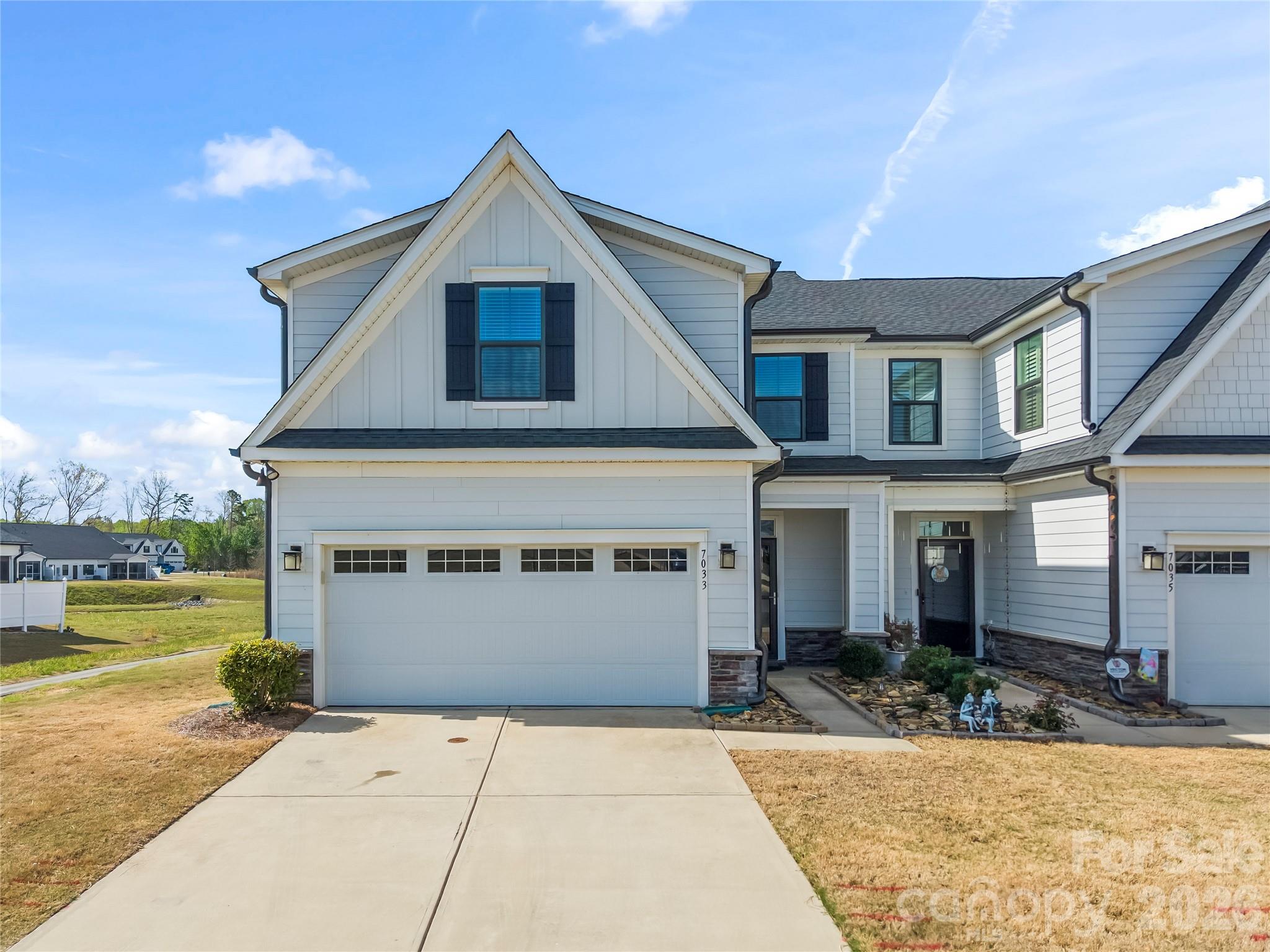 This beautifully maintained end-unit townhome, built in 2021, is loaded with upgrades and is a must-see. The main-level primary suite features a tray ceiling, walk-in closet, and an ensuite bath with tile floors, a double vanity, and an upgraded walk-in shower with a bench and dual shower heads. The kitchen is thoughtfully designed with quartz countertops, an island with bar seating, stainless steel appliances—including a gas range AND second wall oven—and a walk-in pantry. It flows into the dining area and living room, which opens to a covered back patio—perfect for relaxing or entertaining. A conveniently located laundry room and half bath complete the main level. Upstairs, you’ll find two additional bedrooms, a full bath, and walk-in attic space for easy storage. Enjoy outdoor living on the covered back porch overlooking newly planted trees, creating a peaceful, arboretum-like setting. Additional features include upgraded 2” blinds, and with the home built in 2021, you’ll have peace of mind knowing the roof, HVAC, and water heater are all just a few years old. Community amenities include a clubhouse, outdoor pool, walking trails and picnic area. Conveniently located in Indian Trail, this home offers easy access to Crooked Creek Park, the Indian Trail Greenway, and shopping and dining at Sun Valley Commons. Enjoy nearby parks, farms, and community events, all while being just a short drive to Matthews, South Charlotte, and Uptown Charlotte.