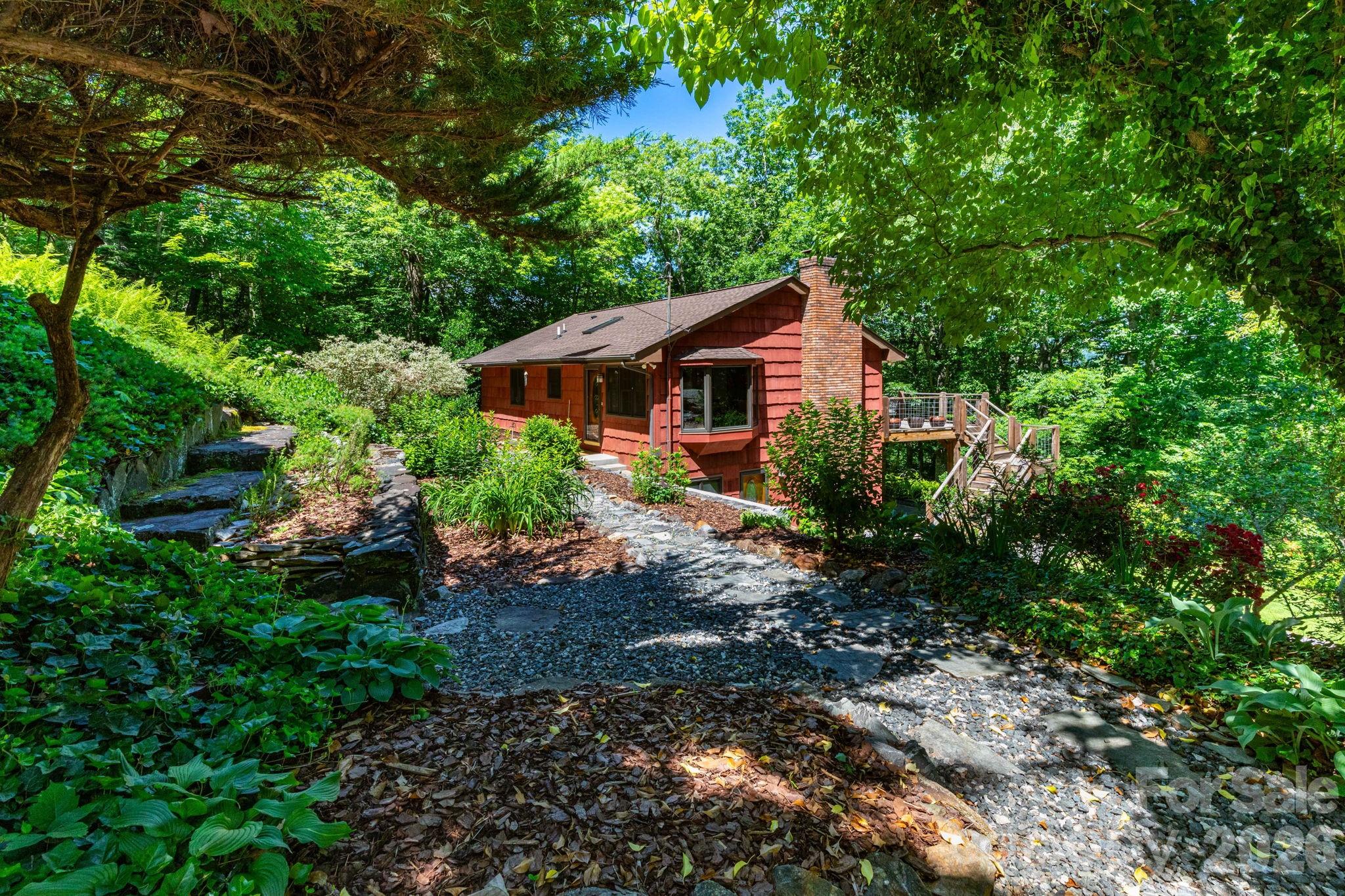 You must see this one in person to experience the real allure of this mountain oasis! Discover the perfect blend of mountain charm, privacy, and convenience at 168 Blossom Ridge. This beautifully maintained 3-bedroom, 2-bath home welcomes you with vaulted ceilings, rich wood accents, and gorgeous hardwood floors throughout. The open-concept living area features a bay window dining space and a wall of sliding glass doors that capture winter mountain views, with the potential for year-round vistas through selective tree pruning. The inviting living room centers around a wood-burning fireplace, while the kitchen offers stainless steel appliances, a large breakfast bar, and oversized pantry. The main level includes a spacious bedroom with a walk-in closet and full hall bath. The finished lower level features a large family room with a woodstove, two additional bedrooms, a full bath, additional exterior entrance, and a custom laundry room with built-in cabinetry and workspace. Step outside to enjoy the expansive deck with views, covered patio, shaded backyard with firepit, and exceptional terraced landscaping. Garden beds, mature blueberry bushes, asparagus, mint, and more create a true outdoor retreat. A detached garage provides excellent workshop or storage space. Enjoy high-speed internet, short-term rental potential, and a welcoming community. Surrounded by nature yet within easy reach of downtown Asheville, shopping, dining, and everyday conveniences, this property offers the best of both worlds! Schedule your showing today and experience everything 168 Blossom Ridge has to offer.