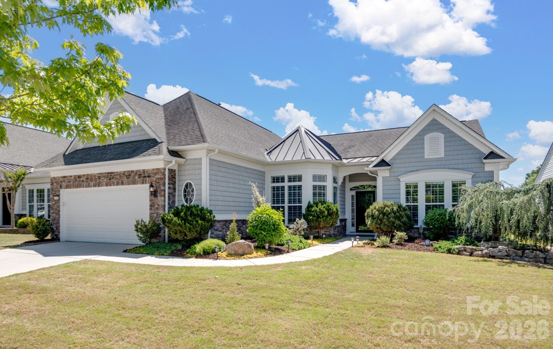Set within the highly sought-after Sun City Carolina Lakes, this move-in-ready Cumberland Hall model offers refined living with elevated upgrades and exceptional indoor-outdoor spaces - perfectly positioned on a premium homesite that originally commanded a $55,000 lot upgrade, enhancing both lifestyle and long-term value. Enjoy tranquil water views and a desirable location within the community.

A landscaped walkway leads to a covered entry and welcoming foyer, highlighted by a contemporary chandelier. Just off the entry, double glass doors open to a private office or study - ideal for remote work or quiet retreat.

The open-concept layout is designed for both everyday comfort and entertaining. A bright breakfast area with tray ceiling flows into the well-appointed kitchen featuring a large island, granite countertops, tile backsplash, stainless steel appliances, and gas range with hood. The breakfast bar connects seamlessly to the spacious living and dining areas, where a classic chandelier adds warmth and charm.

A sunroom surrounded by windows offers abundant natural light and serene water views, creating a perfect year-round retreat. The private primary suite features a tray ceiling and a well-appointed ensuite with extended dual-sink vanity, built-in vanity space, tiled finishes, and a glass-enclosed walk-in shower.

Notable upgrades include crown molding, upgraded wood flooring, tiled baths, plantation shutters, and two additional closets added during construction. The laundry room offers built-in cabinetry and a utility sink.

Outdoor living shines with a screened porch featuring EZE-Breeze panels, cathedral ceiling, ceiling fan, and mini-split HVAC, plus an extended paver patio with stone walls and custom landscaping overlooking the water.

An extended garage accommodates a golf cart or additional storage. Residents enjoy resort-style amenities including golf, tennis, pickleball, pools, fitness center, and vibrant social clubs.