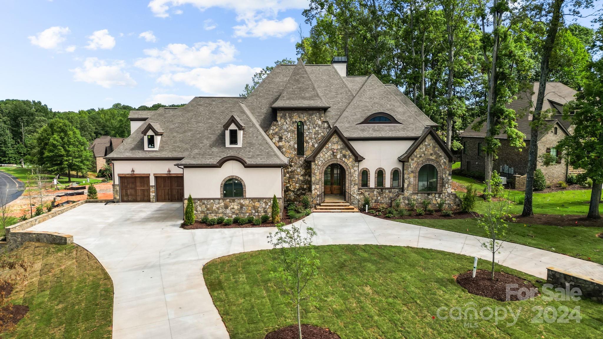 An absolutely stunning CUSTOM home in the exclusive GATED community of Longbrooke, combining European style and modern accents to create a unique estate situated on a tree lined corner lot. The exterior is designed using stucco, stone and brick with cedar headers and gas lanterns. Inside are cathedral ceilings, arched entryways and site finished hardwoods that compliment an ultra desirable floor plan. Large primary suite on the main floor along with an office and laundry room. Take the ELEVATOR upstairs to three additional bedroom suites, media and bonus rooms and a SECOND LAUNDRY room. The walk-in attic and utility area have tons of space for additional storage. Entertain by the fireplace in the great room OR enjoy an evening fire outdoors on the large covered patio overlooking the rear yard with endless potential to create a Summertime oasis. Schedule a tour of this elegant and luxurious property to fully envision all the possibilities.