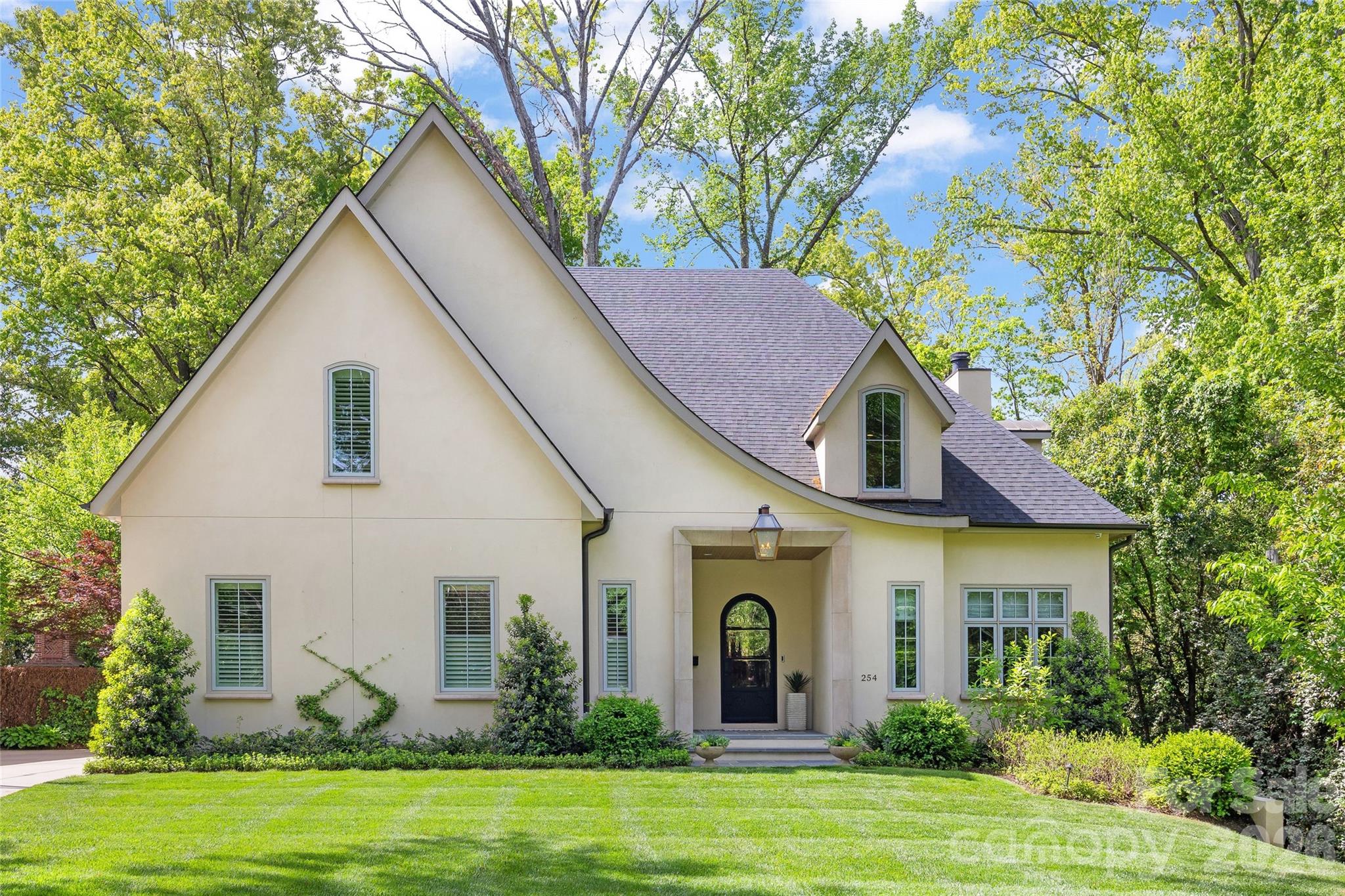 Stunning custom home in the heart of Eastover, built by Knight Construction in 2022 and thoughtfully designed with exceptional detail and designer-grade finishes throughout. Situated on a .37-acre lot, this 6BR/5.5BA residence offers over 5,200 sq/ft across 3 beautifully finished levels. Open main level features white oak hardwoods, gracious foyer, and incredible kitchen with custom cabinetry, quartz surfaces, waterfall island, and top-tier appliances including ILVE gas range. Generous family room with coffered ceiling and cast stone fireplace and office/guest room with en-suite bath. The dining room with built-in bar flows seamlessly to a covered rear porch with vaulted ceiling, fireplace, and grilling area—all overlooking the turfed rear yard with new fencing and lush landscaping. Luxurious primary suite with spa-like marble bath and expansive custom closet. Upper level offers 3 spacious secondary bedrooms and bonus room, while the impressive lower level includes a rec room, exercise room, guest suite, and abundant storage.  Live next to neighborhood parks, shops, grocery, and dining; absolutely unbeatable location in one of Charlotte’s most desired neighborhoods!