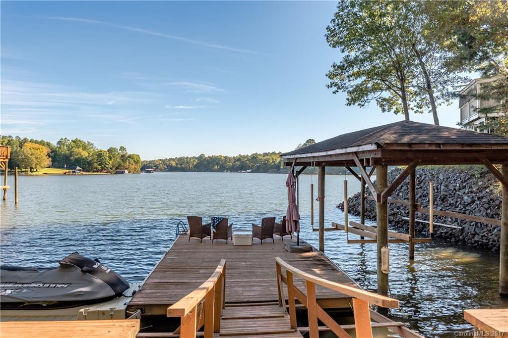 Waterfront on Tega Cay peninsula on Windjammer Cove, Lake Wylie. Lake views from almost every room in the house! Covered Boat Slip with Lift, Floating Dock, Wave Runner Port, Deck & sandy beach. Main floor master with coffee/wet bar plus 2nd master upstairs. Lake views in all bedrooms! Kitchen with stainless & granite opens to Great room. Decks off main & lower level. Close to Windjammer Park, waterski shows in summer, beaches, playground & pavilion. Fort Mill School District. Watch video!