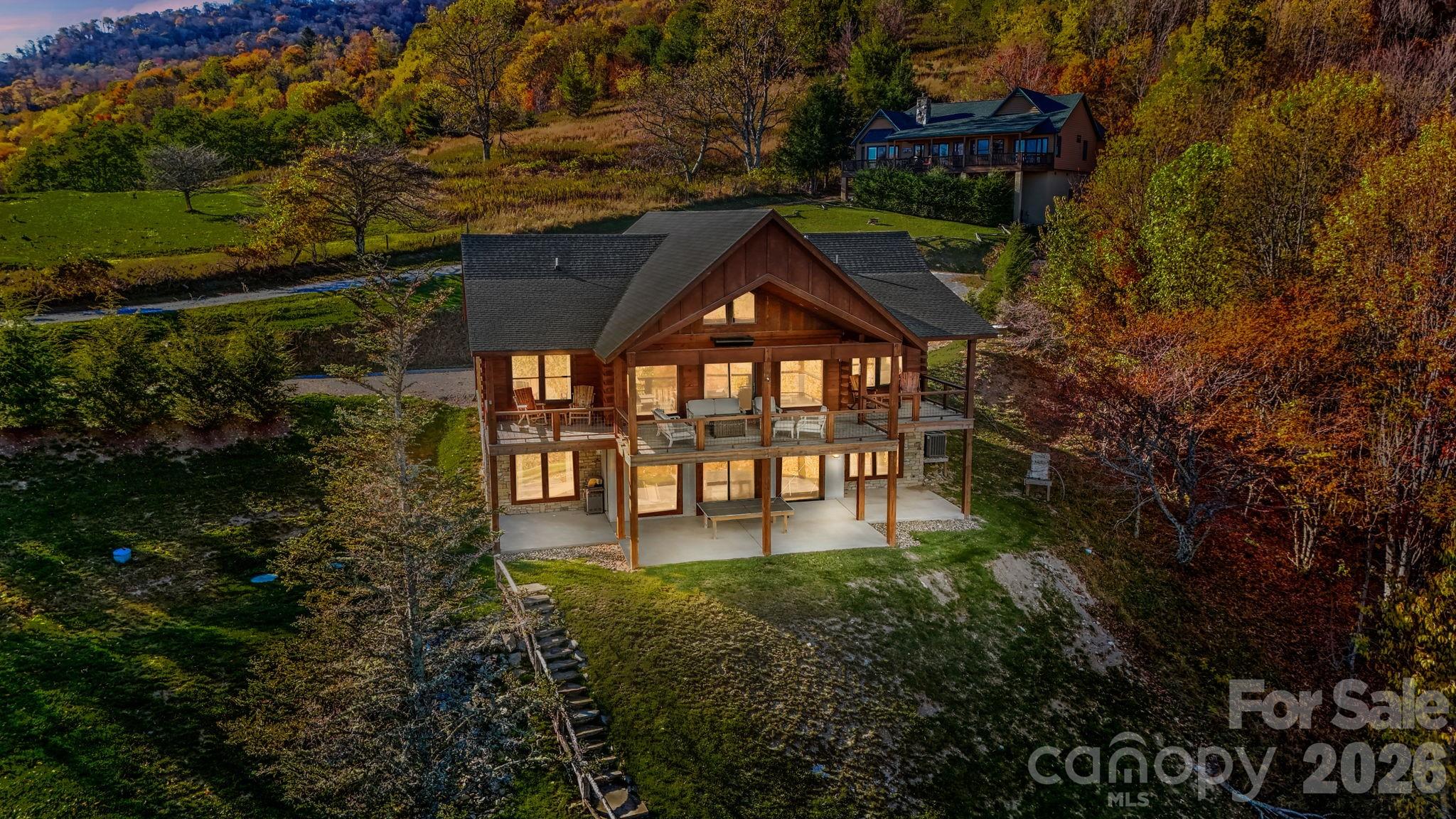 "Escape to 'Amazing View Lodge,' a big, beautiful 4-bedroom 4.5-bathroom (each bedroom has an ensuite bathroom) cabin where luxury meets the landscape in perfect harmony. This custom-built retreat offers an experience beyond compare, with a sprawling deck that serves as your private viewing platform for stunning mountain views and stargazing, or enjoy an evening with a warm fire, crisp air, and endless skies at the firepit. Inside, a stone fireplace and rich wood finishes create a cozy yet grand atmosphere, while multiple living spaces provide ample room to relax and reconnect. A kitchen designed for both serious cooking and relaxed gathering, it boasts a spacious layout with a generous island, a gourmet range, and custom Koch rustic cherry briarwood cabinetry. The lower-level offers a sprawling family-friendly oasis designed for both relaxation and entertainment. Gather around the cozy fireplace for a movie night or head to the dedicated game area for endless fun. This impressive space is complemented by two bedrooms, each with its own full en-suite bathroom. From the moment you arrive, you'll be immersed in a world of tranquility, framed by some of the most amazing views the region has to offer." Located in Banner Elk minutes to downtown, Beech Mountain and the area ski resorts! An incredible home built with superior wall foundation, 8" easter white pine double V authentic exterior corners, all logs are clear treat pressure treated at factory, spray foam insulation on roof deck for exceptional insulation values, a Generac 22kw whole house backup generator serviced annually, whole house dehumidification tied into the HVAC system. Short-term rental projection up to 65K! A truly gorgeous mountain home awaits you! Furnished with a few exceptions! Seller is an NC Broker