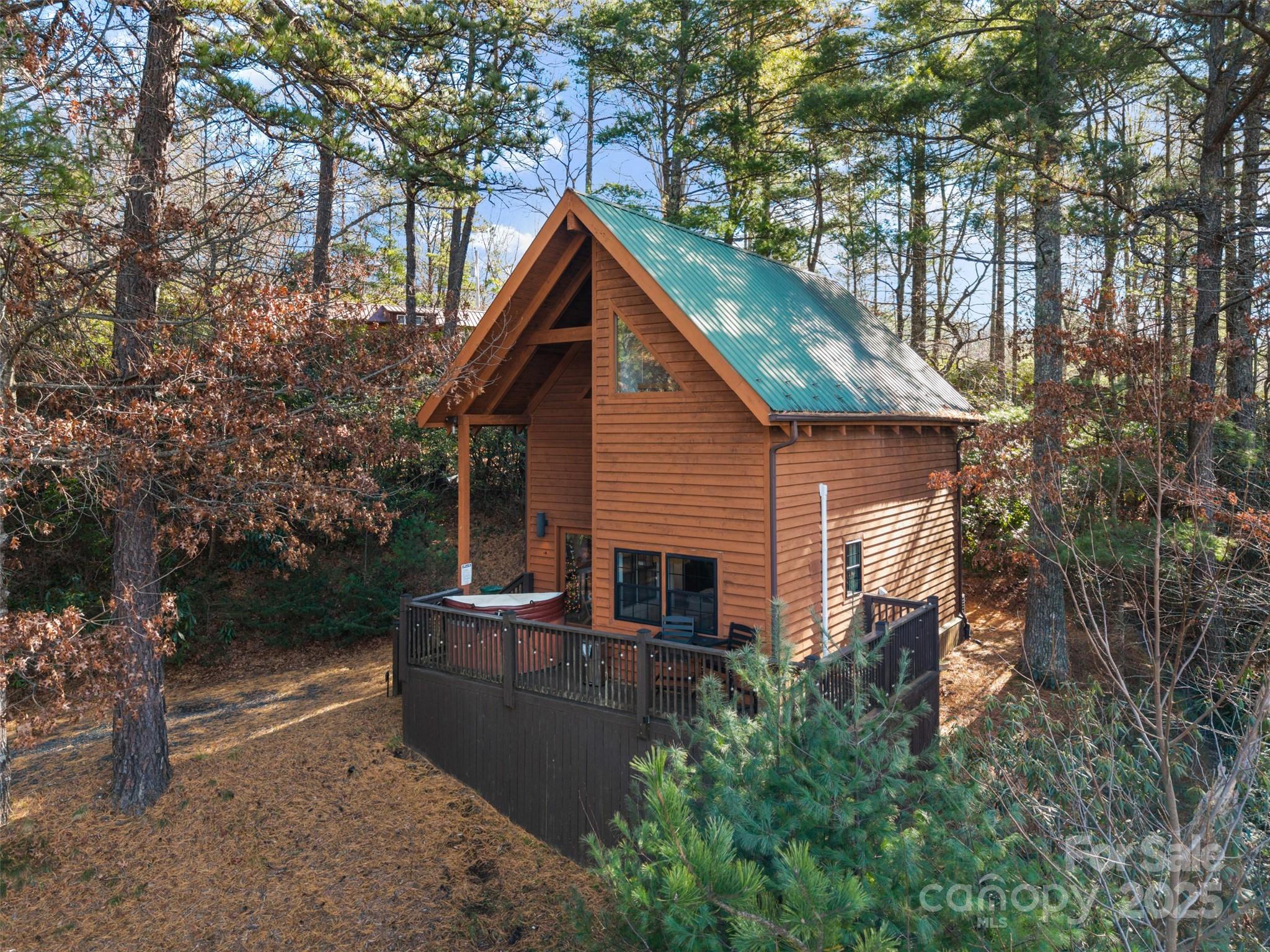 Discover the perfect blend of modern comfort and classic mountain charm in this beautifully updated 2-bedroom, 2-bathroom cabin, ideally located just minutes from the Blue Ridge Parkway. Whether you're searching for a primary home, a peaceful retreat, or a turn-key STR investment property, this inviting cabin captures everything people love about mountain living.

Step inside to a warm, open living space featuring soaring ceiling heights, rich hardwood flooring, and stunning tongue-and-groove ceilings with exposed beams that instantly set the tone for relaxation. Large windows draw in natural light and frame the serene, seasonal mountain views, giving the home a cozy yet expansive feel.

The thoughtfully updated kitchen is perfect for everyday living and entertaining, offering stainless steel appliances, granite countertops, and plenty of cabinet space. The open layout keeps you connected to the living room, making it easy to enjoy time with family and friends.

Both bedrooms offer comfortable retreats, and with two full bathrooms, everyone gets space and privacy. The convenience of in-unit laundry adds to the ease of living whether you’re here full-time or visiting for a weekend escape.

Step outside, and the magic of mountain living continues. Relax in the outdoor hot tub, fire up the grill, or enjoy a meal in the picnic area surrounded by nature. It’s the kind of outdoor space guests rave about and exactly why this cabin performs so well as a vacation rental.

Located in an established vacation rental program, this cabin offers immediate income potential with a strong rental history and a setting travelers love: peaceful and private. With the famed Blue Ridge Parkway just minutes away, guests and owners alike enjoy quick access to hiking, overlooks, and some of the best scenic drives in North Carolina.

Beautifully updated, fully furnished, and perfectly positioned for both personal enjoyment and investment, this mountain cabin delivers it all. The Mountains Are Calling...Are You Listening?