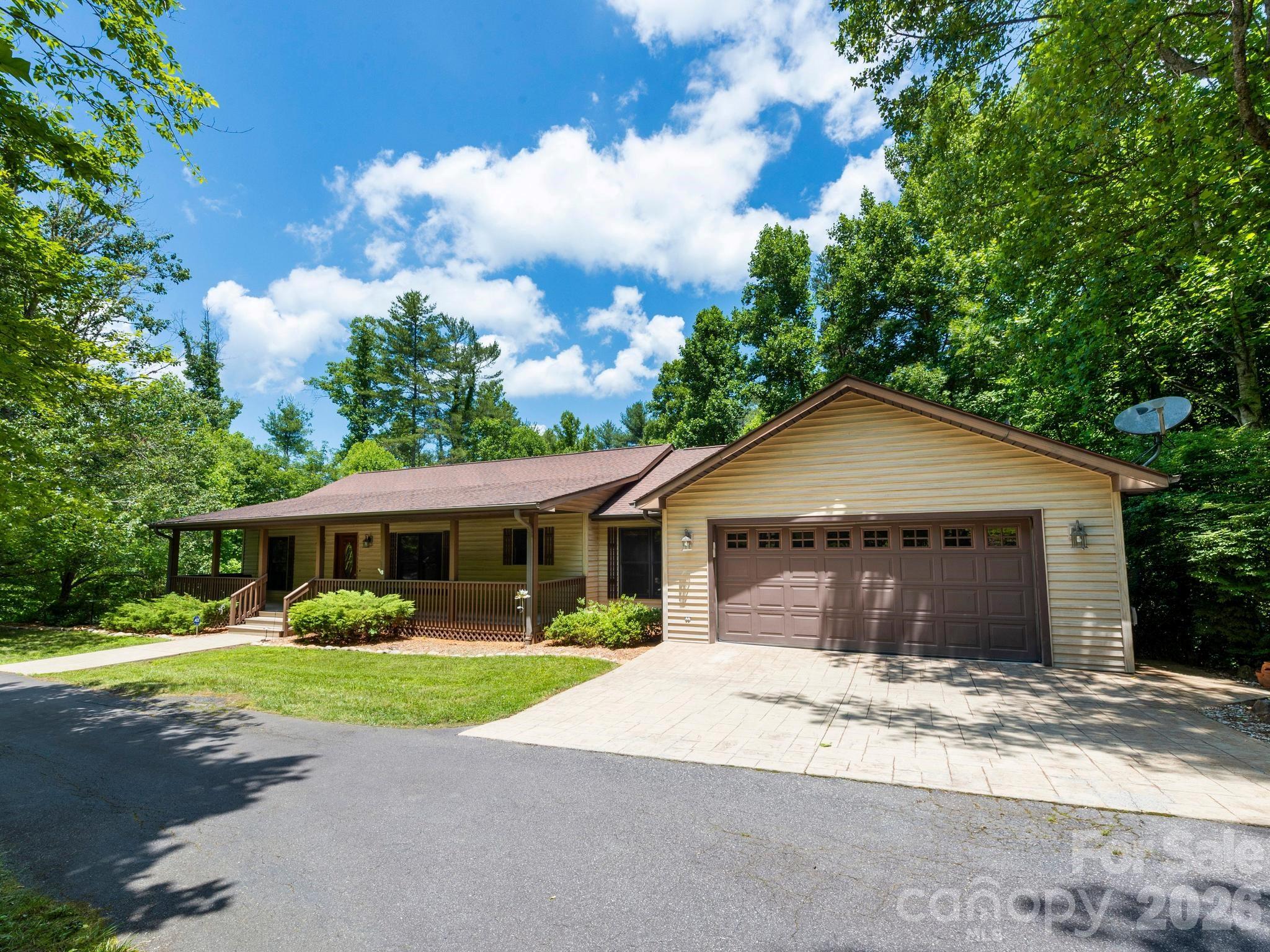 Come home to your front porch swing and a chorus of birds. Enjoy evenings on your elevated back deck overlooking your private yard of almost an acre. You have everything you need on the main level of this home - 3BRs, 2BAs, great room w/gas fireplace, kitchen w/pantry and breakfast nook, spacious laundry room, and an attached 2-car garage. Downstairs, you have ANOTHER attached garage, workshop, BR/office, full BA, rec room/family room, huge screened porch, and tons of storage. The family room has a gas fireplace, and the BR/office has a cedar-lined closet. (Pls note - 3 BR septic, so the lower BR/office isn’t included in the BR count for the house.) Use this level of the home as rec space, guest suite, private office...so many possibilities! *If the buyers like, sellers will remove the electronic chairlift on the stairs prior to closing. Pool table and all appliances convey, including second fridge in garage. Peaceful, woodsy neighborhood with large lots. Convenient pull-thru driveway with an attached garage on each level of the home. Easy access to I-26 w/the privacy and serenity of a dead-end road. 5 min to Weaverville; 15 min to Asheville. Schedule your showing today. There’s room for you, your loved ones, your cars, tools, bikes and more. It’s time to make new memories at 11 Robin Lane.