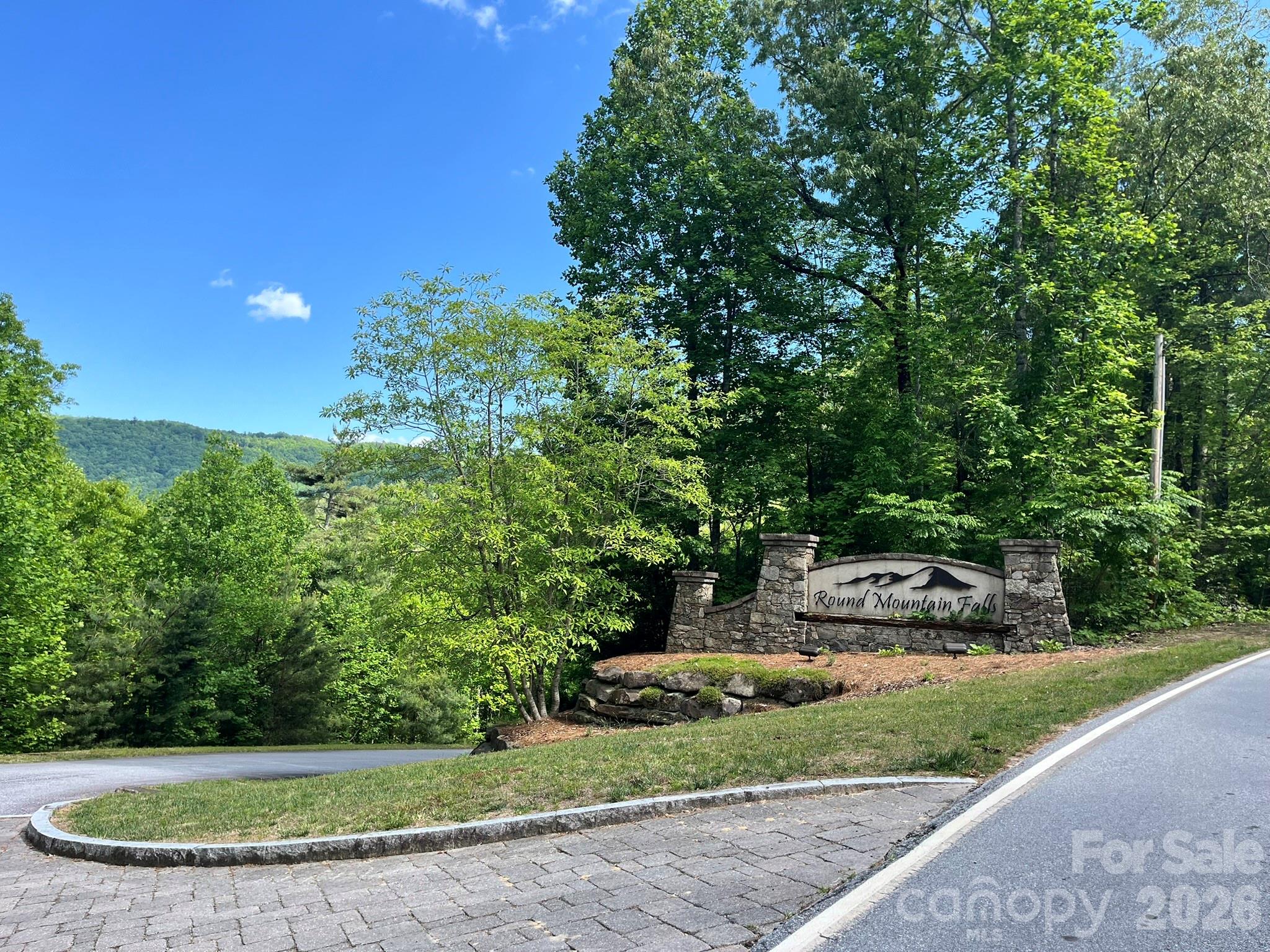 Large, private homesite in the gated community of Round Mountain Falls. This beautiful approx. 2.18-acre lot offers the perfect setting to build your mountain retreat, conveniently located near Brevard and Lake Toxaway. Enjoy the peaceful surroundings and natural beauty of this serene community featuring paved roads, gated entry, a community pavilion, picnic areas, pond, walking and hiking trails, and a picturesque waterfall. Potential long-range mountain views with selective clearing.