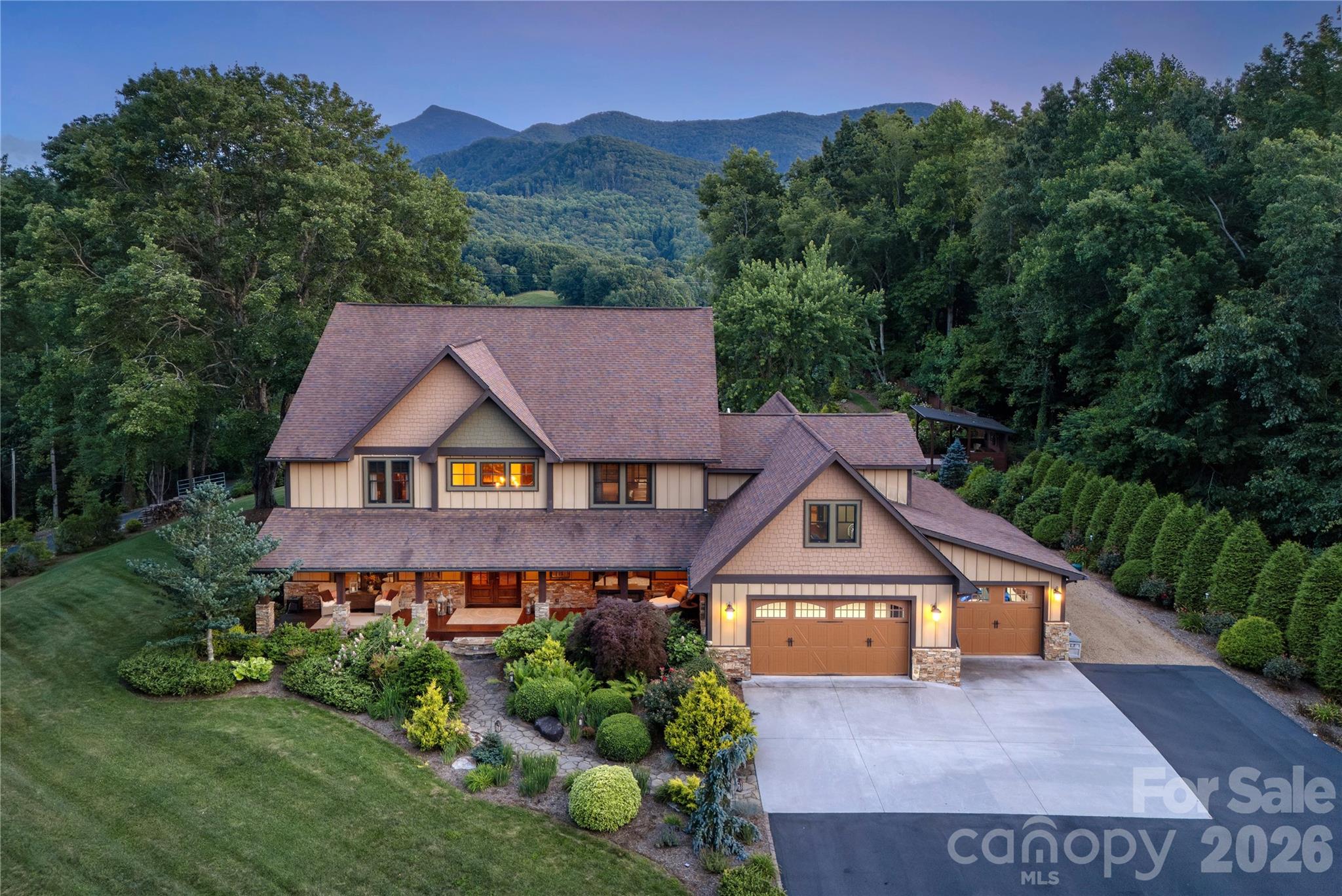 345 Prospect Drive is a 5,400-sq-ft custom mountain estate on almost six acres, showcasing year-round views of Celo Knob from nearly every major living space and the flat backyard. The main level features the primary with vaulted ceilings expansive bathroom with walk in shower and freestanding soaking tub. A chef’s kitchen with professional-grade appliances, leathered granite countertops, a large island with large built in griddle, and abundant storage makes entertaining effortless, whether hosting intimate dinners or large gatherings. All four bedrooms are true en-suites, each with its own private bath, providing exceptional comfort and privacy for owners and guests. Outside, a stone fireplace terrace, hot tub deck, pavilion/stage, and lush landscaping with water features create a resort-like setting that’s both playful and peaceful. A finished attached three car garage with custom cabinetry and mini split to keep you warm in the winter months and a detached workshop/garage add flexible space for vehicles, hobbies, or storage. Thoughtful details throughout—from rich wood floors and custom millwork to multiple laundry stations and well-organized utility areas to a whole house propane generator—make this property as functional as it is beautiful. This is a rare opportunity to own a fully realized mountain retreat just minutes from downtown Burnsville.
