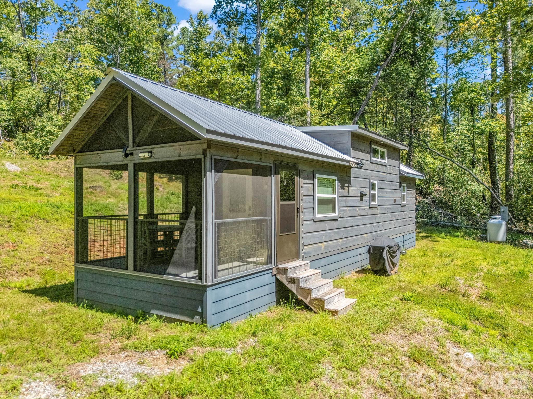 Escape to this charming Green River Log Cabin, perfectly situated on 2.23 private acres in Lake Lure. This serene mountain retreat features a creek and fire pit, creating the perfect mountain getaway setting. Designed with custom finishes, this turnkey cabin offers an open floor plan with cathedral ceilings, a Queen-size bed featuring integrated under-bed storage, sofa bed in the family room, a convenient laundry area, and additional sleeping space with twin beds in the loft. The screened deck, finished with durable Trex, is ideal for outdoor entertaining while keeping the elements at bay. Whether you're seeking a personal getaway or an income-producing Airbnb, this exquisite Green River Log Cabin blends charm, comfort, and investment potential. Notably, the property is equipped with a 4BR MULTI BATH SEPTIC SYSTEM, providing flexibility for future expansion!