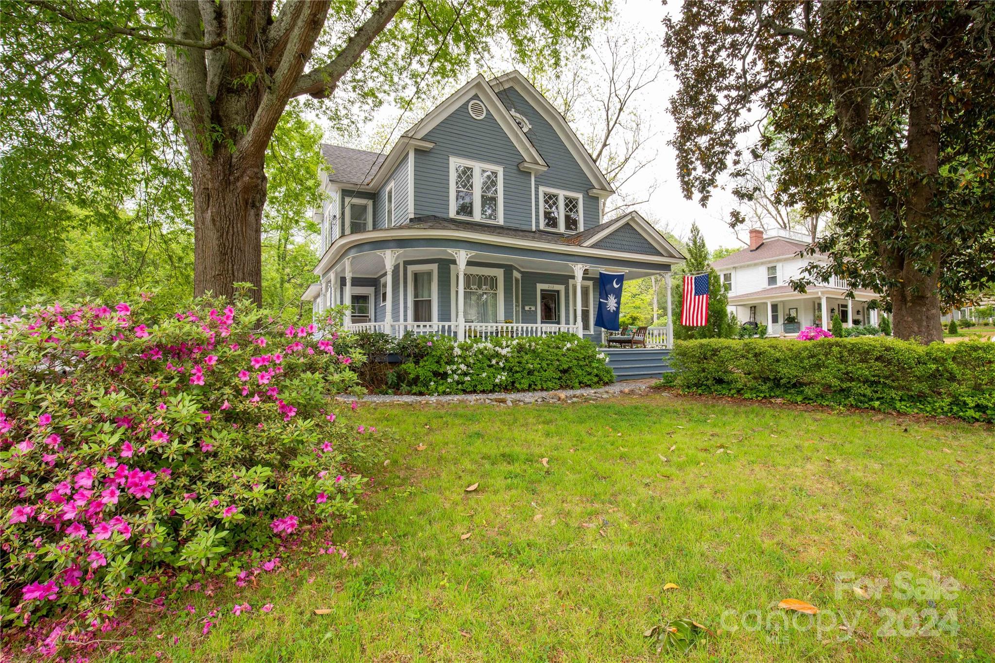 Be whisked away to the elegance of the Victorian era with this gorgeous 2 story home built around 1888!  Flowering shrubs and greenery accent the walkway up to that wrap around porch where afternoons will be delightful with the sunlight cascading upon your view and an impressive 1/2 acre lot.  A designer's dream where original character blends with upscale modern creating a warm and inviting living space.  Gleaming hardwoods, detailed windows, beadboard accents and those beautiful decorative fireplaces are only the beginning of why you will love everything here!  A spacious kitchen with island and dining area plus a formal dining room gives you ample space to enjoy with guests.  Main level primary suite provides a luxurious space to unwind and includes walk in closet and ensuite with subway tiled walk in shower and soaking tub.  Upstairs accommodates a sitting area, 3 additional bedrooms and 2 full baths with one featuring a claw-foot tub.  Come make this timeless treasure yours!