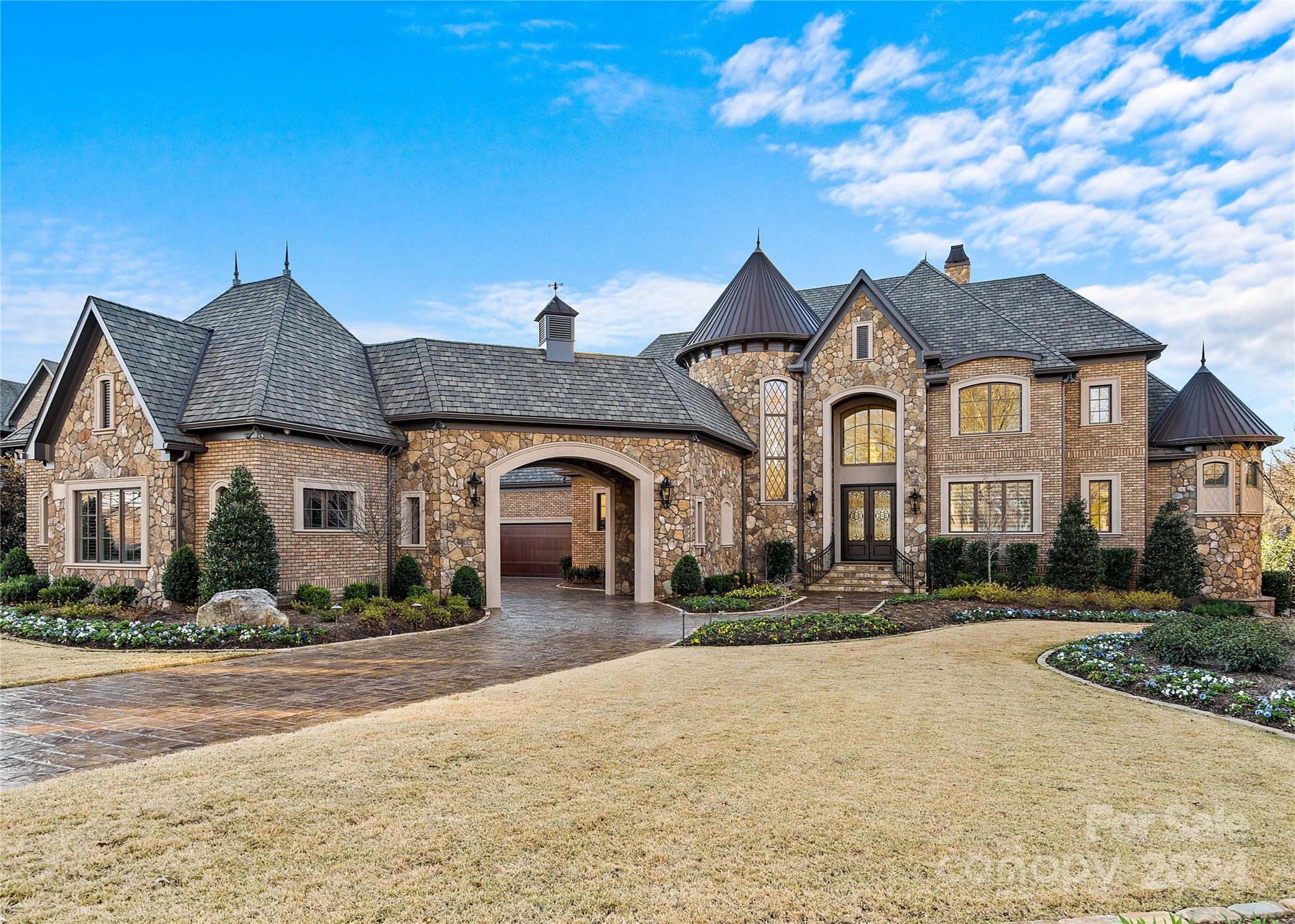 Breathtaking waterfront estate with saltwater pool and spa, on private, lush grounds; in the sought-after gated Skyecroft, showcasing impeccable craftsmanship and luxury throughout. The main chef's kitchen includes top-tier WOLF and Sub-Zero appliances, an ASKO dishwasher, expansive island w/ elegant quartz counters, etc. A second ASKO dishwasher, and built-in MIELE coffee maker in the dining room.  Porcelain floors & crystal chandeliers highlight the turret staircase. An elevator provides seamless access. The owner’s suite features a grand turret shower w/3 heads, quartz vanities, a vanity room, & Bain soaking tub, w/ dual closets. Coffered ceilings & deep wainscotted moldings w/LED lights... The terrace w/ auto screen, and the basement w/ a full kitchenette, dining, home gym, theatre, a full bath & wine cellar, etc. 2 studies; one that can be a 6th bed suite both lead to the pool and spa, outdoor gourmet kitchen, multiple verandas, pond, etc. No stone left unturned. Wow!