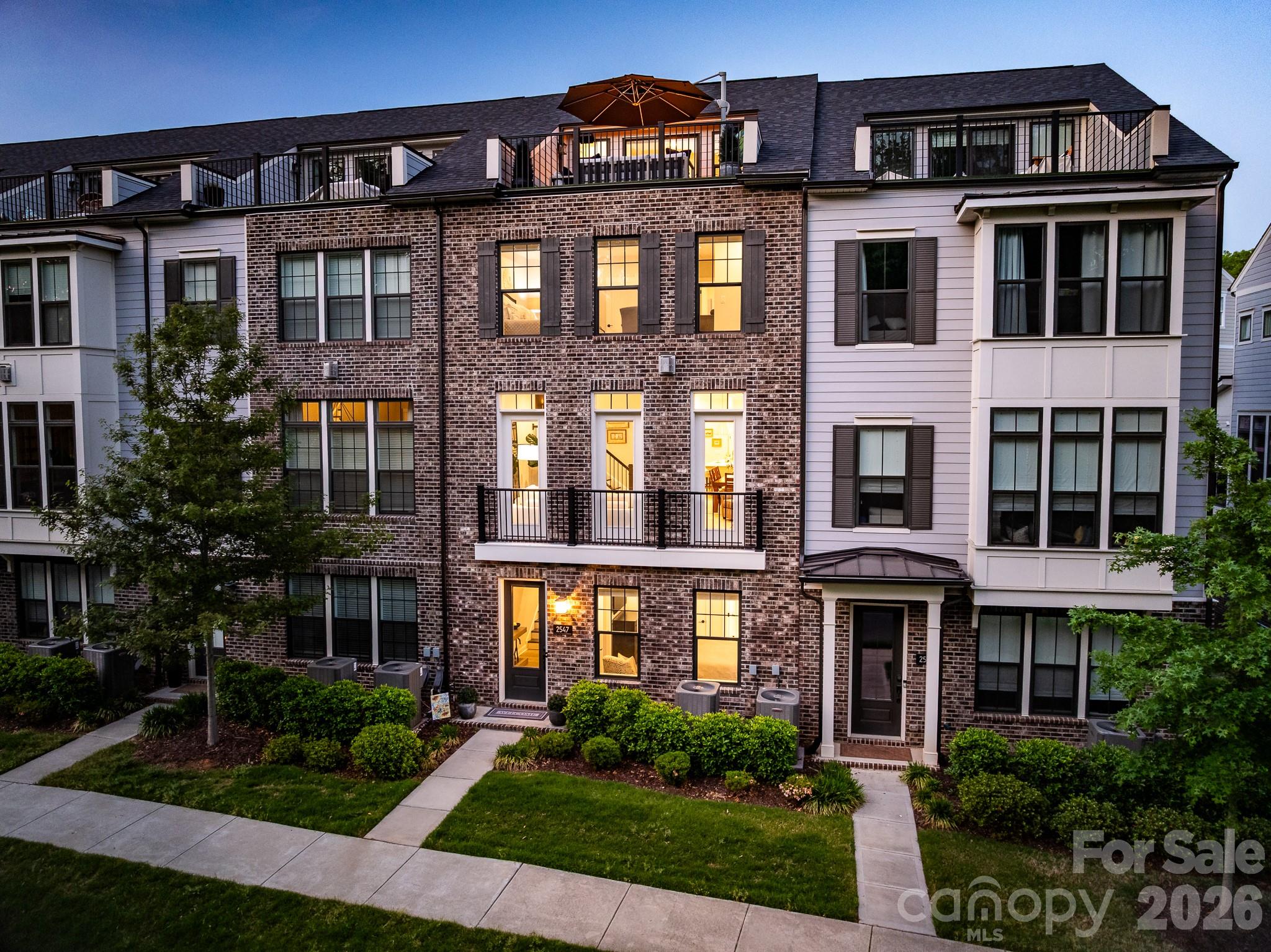 Turnkey four-story luxury townhome in the desirable Elizabeth Glen community, offering pristine condition and an exquisite neutral palette throughout. Lower level garage is a functional highlight featuring premium epoxy flooring, custom built-in cabinetry, and a dedicated workbench area which opens to a first-floor drop zone, welcoming foyer, and a private bedroom with a full ensuite bath. The main level boasts generous formal spaces illuminated by upgraded designer lighting, flowing effortlessly into a chef-inspired kitchen featuring a KitchenAid 6-burner range, ceiling-height soft-close cabinetry, and a statement island with abundant storage. A private covered balcony and a sophisticated, custom bar behind double glass doors create a seamless indoor-outdoor flow on the main floor. The third floor primary suite complete with a sprawling spa-inspired bath distinguished by a custom-added glass shower door unique to this home and an upgraded walk-in closet featuring a custom built-in shoe rack. Across the hall, the secondary guest bedroom also features an upgraded custom closet system. The fourth floor provides flexible ensuite space currently used as an office and exercise area but could be used as bedroom, opening to a balcony and leading to a rooftop terrace. The home is fully wired with ceiling-mounted speakers on all levels, individual room volume controls, and two outdoor terrace speakers that will remain with the property; The specific receiver powering the main living area's surround sound system will convey with the property (amplifiers do not convey). Enjoy added privacy with a tree-lined street view rather than overlooking neighboring homes. This residence seamlessly blends exclusive upgrades, privacy, and modern convenience across four exceptional levels.