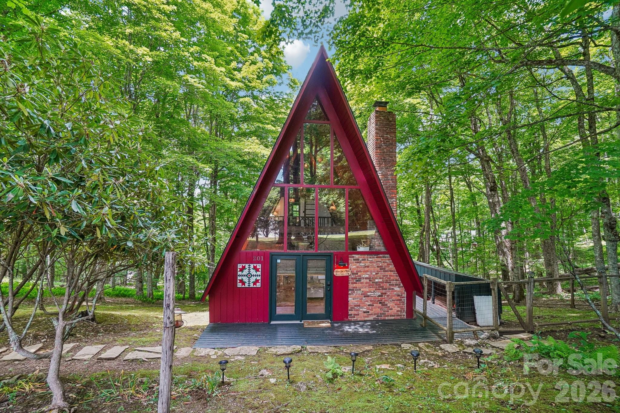 Wolf Laurel Charming A-frame tucked in the woods on a paved road within a gated community, perfectly located near all amenities. Sitting above 4,000 feet, it offers cool summer days. From the moment you step inside this enchanting mountain retreat, you’ll fall in love. The two-story great room features a stone fireplace, updated flooring, and an open layout. The kitchen boasts granite counters, a breakfast bar, and modern lighting. The main-level primary has access to a full bath with a tub/shower combo. A cozy side deck leads to the fenced yard. Upstairs, you’ll find a loft, second bedroom, and full bath with shower, plus a ladder to a third level—ideal for storage or a hangout space for older kids. With a newer furnace, the flat-to-sloping lot sits close to the country club, pro shop, fitness center, and Village Club amenities. Just minutes from Hatley Pointe Ski Slopes, mountain biking trails, and local dining. Mostly furnished, with a few exceptions including artwork, small furniture pieces, and personal items. Must see, great spot for part or full time living.