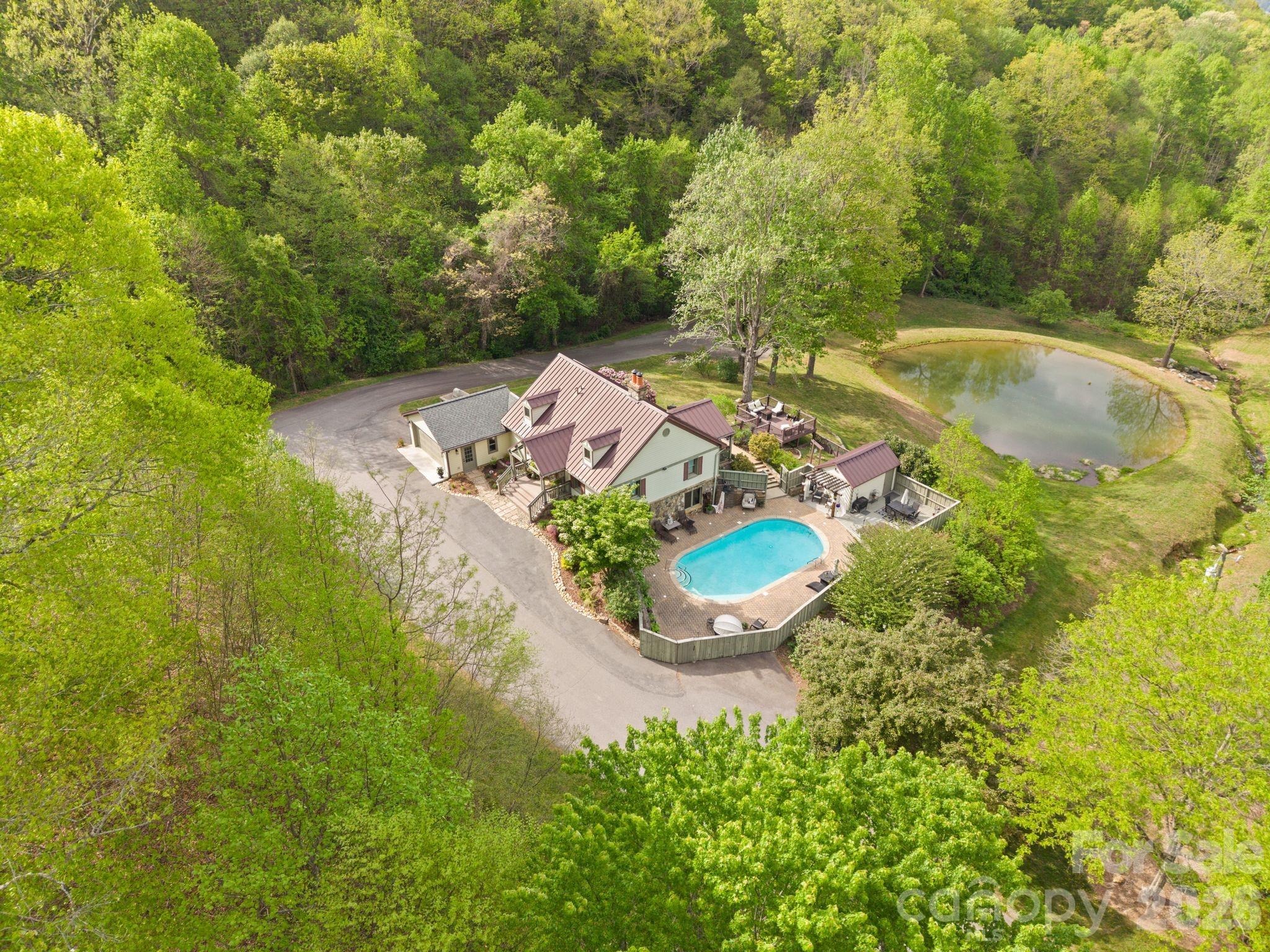 Beautiful sanctuary near Asheville with mountain and pond views, saltwater pool, your primary bedroom with on-suite bath on the main floor and beautiful outdoor viewing decks - all within the gated community of Blue Mist Farms.

This stunning mountain retreat welcomes you with soaring high ceilings, rich hardwood floors, and a striking stone fireplace that anchors the main living space—creating a warm, inviting atmosphere that truly feels like a private sanctuary. Thoughtfully designed for both everyday living and effortless entertaining, the layout flows seamlessly to expansive outdoor spaces where you can relax, host, and take in the serene natural surroundings.

The main-level primary suite offers comfort and convenience, while additional bedrooms and a spacious lower-level rec room provide plenty of room for guests or gatherings! Whether you're hosting weekend getaways or enjoying quiet evenings at home, this property offers the perfect balance of luxury and lifestyle.

Residents enjoy access to beautifully maintained amenities including tennis and pickleball courts, a community firepit, and inviting gathering spaces—all just a short drive from Asheville’s dining, shopping, and vibrant culture.

Septic permit allows for 4 bedrooms - the Buyer could look into the potential of adding another bedroom!

Come experience the magic for yourself—schedule your private showing today!