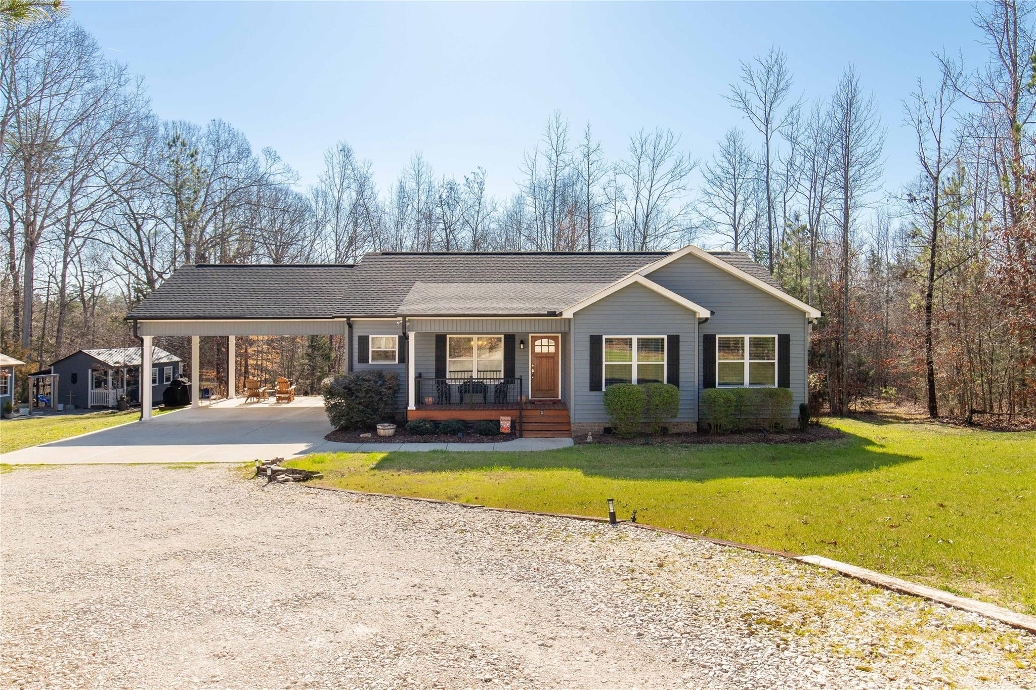 Welcome to 2925 Anderson Burgess Rd, your little slice of country living! Situated on a peaceful and private 8-acre tract of land this gated property offers endless possibilities. The custom-built three-bedroom, two-bath ranch-style home warmly invites you in after enjoying the outdoors on your land. The 24x24 covered carport offers extra space for outdoor entertaining, as does your screened-in rear porch affording views into the serene privacy of the wooded acreage. Inside you'll find warmth and comfort in the custom-designed interior, from the open living/kitchen space with its oversized island including additional storage on both sides, to the custom built-ins with an electric fireplace insert. The primary bedroom offers a walk-in closet and a custom en-suite bath with an extended dual vanity and tile shower. The property also offers a 12x20 wired shop, an 8x10 shed, and a gorgeous firepit area. This one-of-a-kind hidden gem is sure to impress!