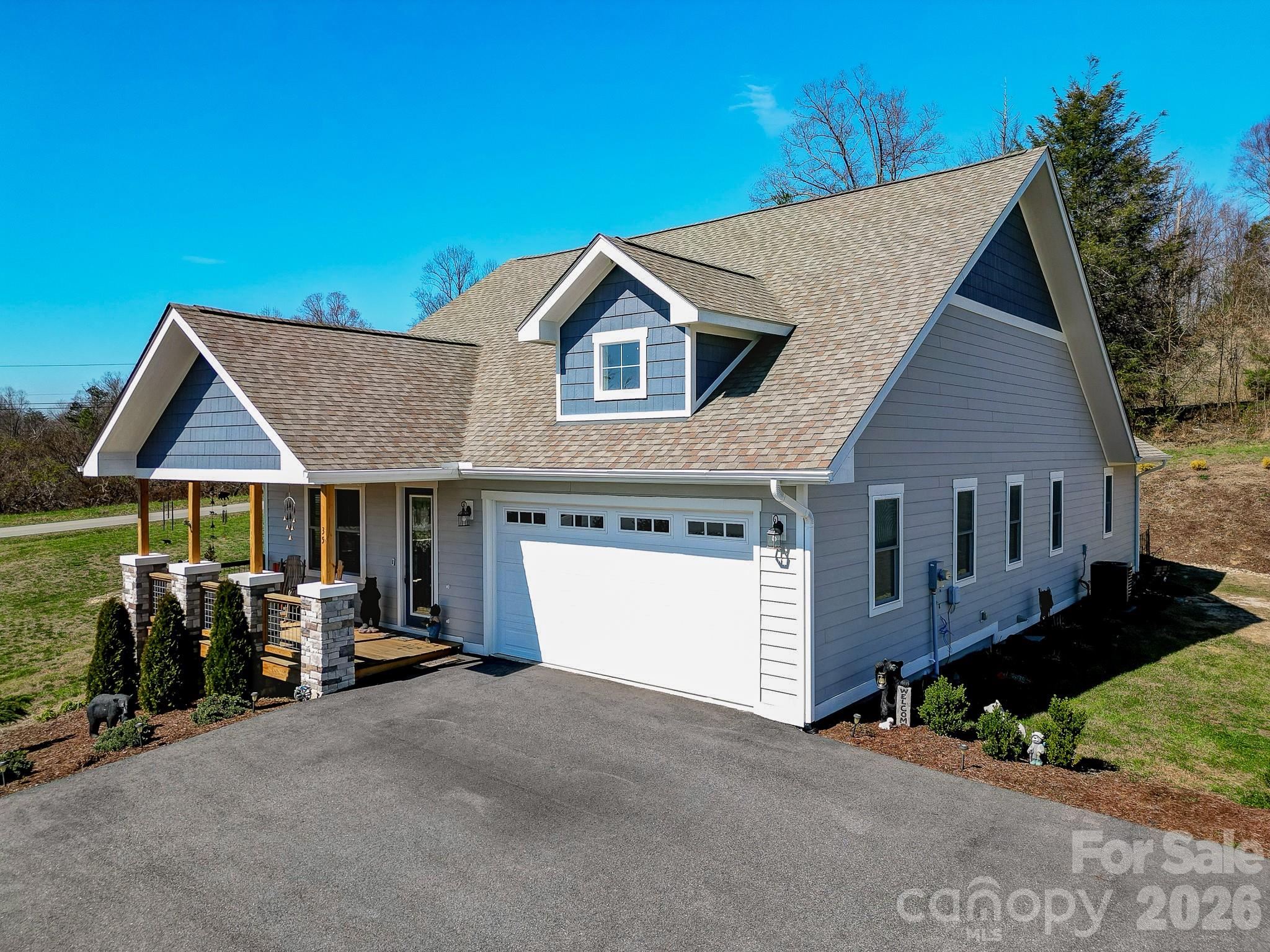 Situated on almost 1 acre on a huge corner lot and located in the heart of Hendersonville, NC, this home offers the perfect balance of peaceful living and everyday convenience, just minutes from charming downtown, renowned apple orchards, local vineyards, shopping, dining, and top tier healthcare. Welcome to this beautifully crafted newer construction home offering space, style, and functionality. This 3 bedroom, 2 bath one level home features over 1800 square feet of thoughtfully designed living space and an expansive yard that’s hard to find. Inside, you’ll love the open floor plan highlighted by soaring 10 foot ceilings, 8 foot doors, and rich wood flooring that flows throughout the main living areas. The oversized kitchen island serves as the centerpiece of the home, complemented by ample cabinet space for storage and organization, making it ideal for entertaining or everyday living. The stone faced gas fireplace adds warmth and charm to the living room perfect for relaxing here in the mountains of WNC. The spacious primary suite is a true retreat, featuring double closets, a beautifully tiled walk-in shower, and a double vanity. Storage is abundant throughout the home, offering both functionality and convenience. Enjoy outdoor living year round on the oversized covered front and rear porches overlooking the large back and side yard, complete with a storage shed for tools or hobbies. The attached two car garage includes a utility sink, adding even more practicality. This home delivers modern comfort, generous space, and an unbeatable Hendersonville location, schedule your showing today!