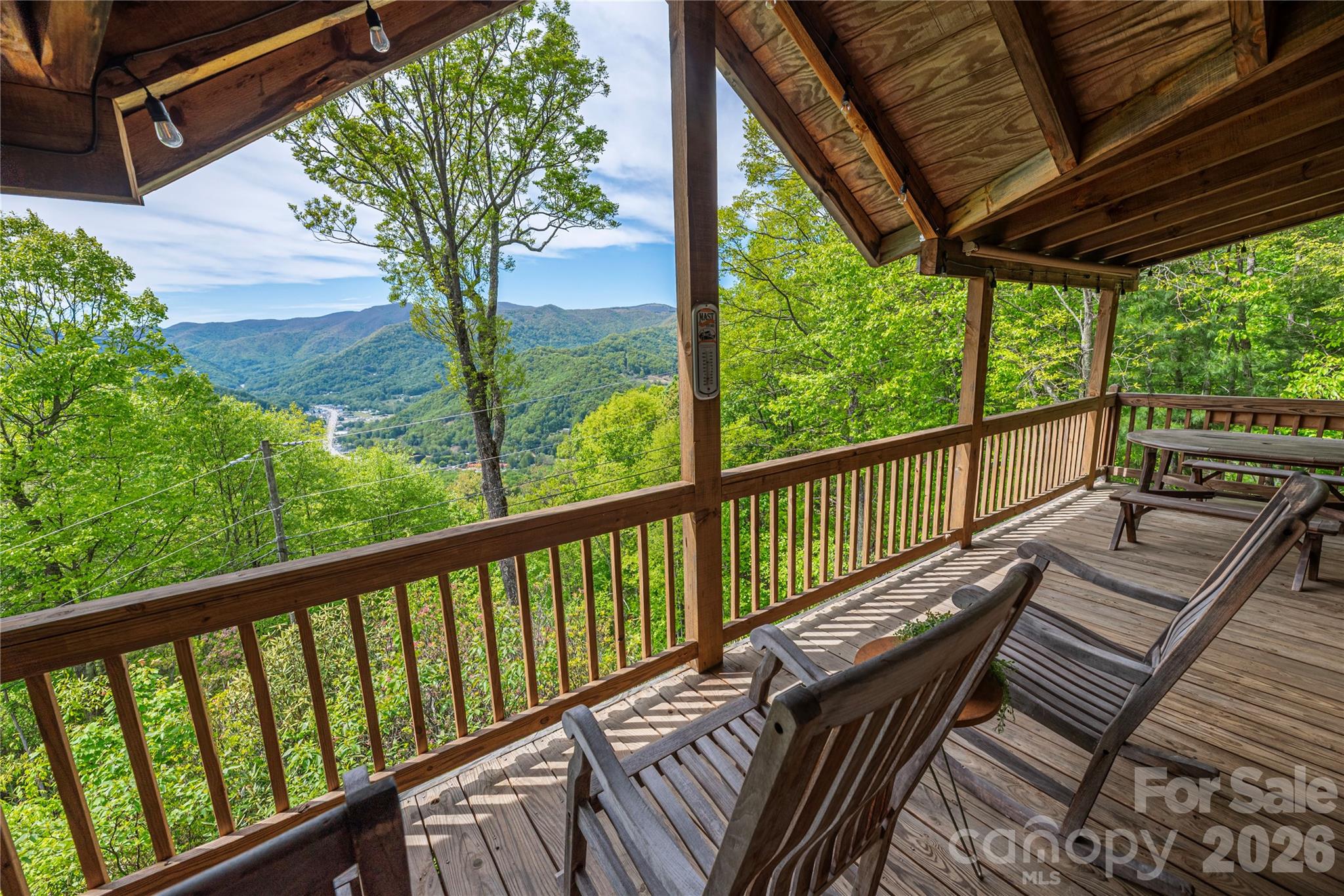 Perched high above the mountains, this stunning Arts & Crafts–style cabin retreat offers breathtaking long-range views, rustic elegance, and a true “on top of the world” living experience. Featuring two bedrooms plus two spacious bonus rooms and three and a half bathrooms, this home provides exceptional flexibility for guest accommodations, home offices, hobby rooms, or additional sleeping areas. Thoughtfully designed with an open floor plan, vaulted ceilings, exposed beams, and expansive windows, the home is filled with natural light and showcases the beauty of Western North Carolina from nearly every room.
The main level features a welcoming great room with a cozy wood-burning fireplace, seamless flow into the dining area, and an updated kitchen complete with beautiful countertops, stainless steel appliances, custom cabinetry, and a spacious island—perfect for everyday living and entertaining. The primary suite offers vaulted ceilings, private deck access, and a spa-like ensuite bath, creating a peaceful retreat with incredible mountain views. Multiple covered decks extend the living space outdoors and provide the perfect setting for relaxing, dining, and taking in unforgettable sunrises and sunsets over the surrounding peaks. The private wooded setting offers a sense of seclusion while still allowing easy access to nearby amenities. 
Whether you are searching for a mountain getaway, full-time residence, vacation home, or investment property with short-term rental potential, this exceptional home delivers privacy, comfort, and timeless mountain charm. This is more than just a home—it is a lifestyle retreat in the clouds, offering unmatched views, peaceful surroundings, and a true escape from the everyday.