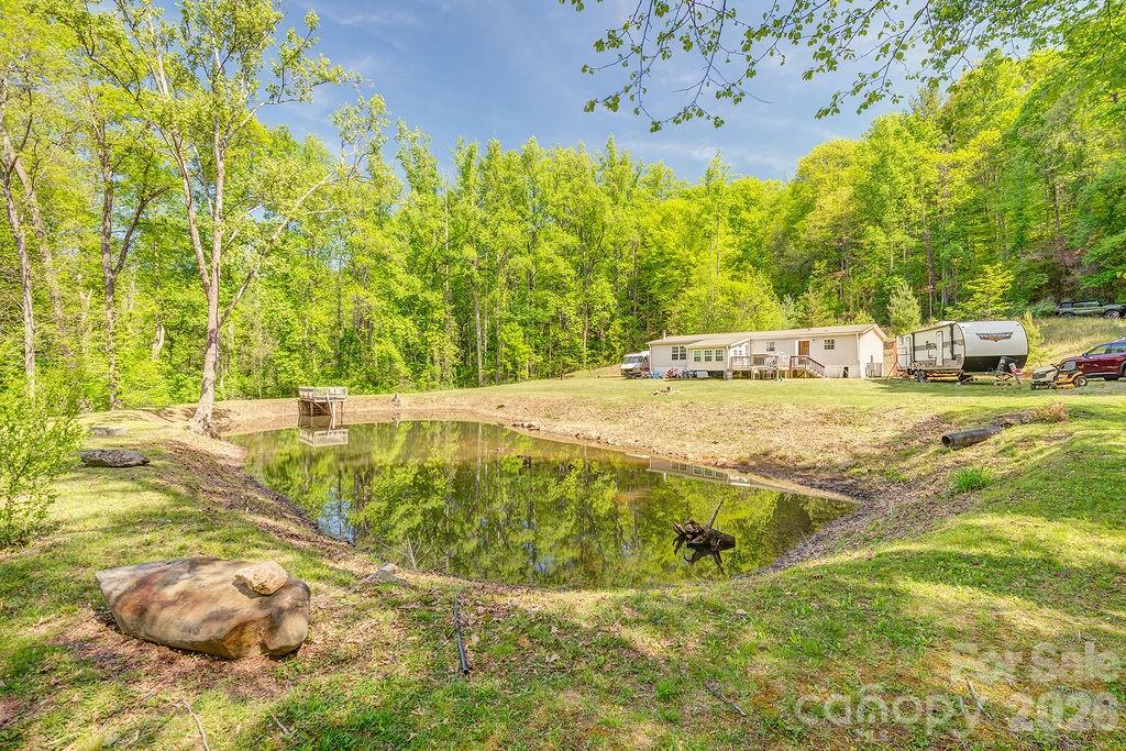 Tucked away in Reems Creek area, this property offers a rare combination of privacy, natural beauty, and acreage. Featuring a private pond and serene creek frontage, the land invites you to enjoy the outdoor area. The expansive wooded acreage stretching behind the homesite, this property provides the perfect setting for those seeking space, or a nature-filled retreat. Whether you’re envisioning a mountain getaway, or investment opportunity, the possibilities here are wide open. Conveniently located from downtown Weaverville, and Asheville, while still feeling worlds away in your own private sanctuary.  This is a court order Sale.