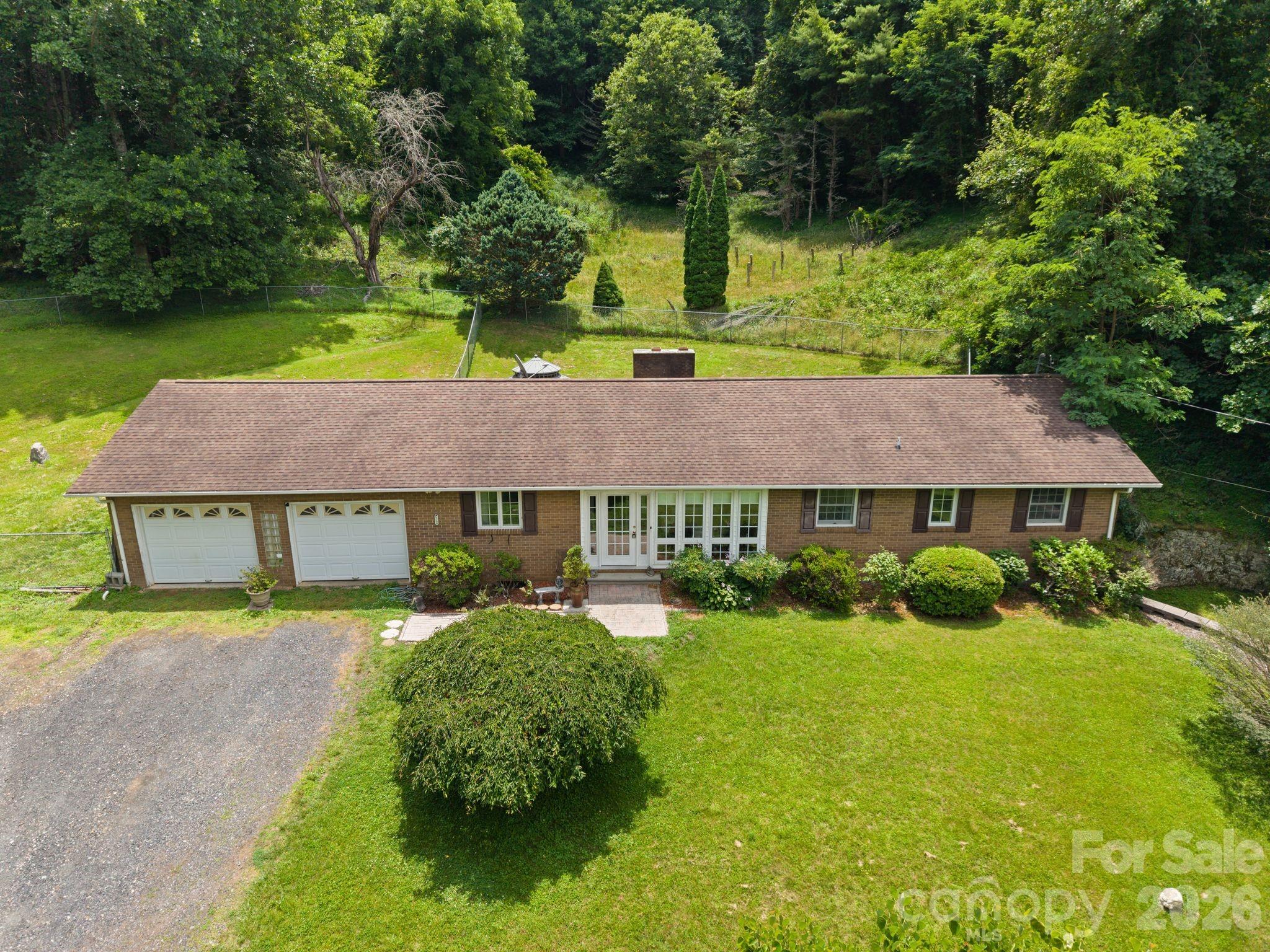 Welcome to 538 Baccus Siding Rd, where comfort, space, and country living come together on 5 unrestricted acres. This well-maintained brick ranch offers 3 bedrooms, 2 full bathrooms, a spacious two-car garage, and a full basement, providing plenty of room for storage and hobbies.

Step inside to find a move-in ready home with a warm and inviting layout designed for comfortable everyday living. The beautiful sunroom is the perfect place to enjoy your morning coffee, unwind with a good book, or simply take in the peaceful views of the surrounding property.

Outside, you'll love the fenced backyard featuring a cozy seating area that's ideal for entertaining family and friends, grilling out, or relaxing after a long day. With unrestricted acreage, you'll have the freedom to create the homestead you've always wanted, bring your animals, start a garden, or simply enjoy the privacy and open space.

Whether you're searching for a full-time residence, hobby farm, or a home with room to grow, this property offers endless possibilities in a beautiful mountain setting. Don't miss your opportunity to make this move-in ready home your own—schedule your private showing today!