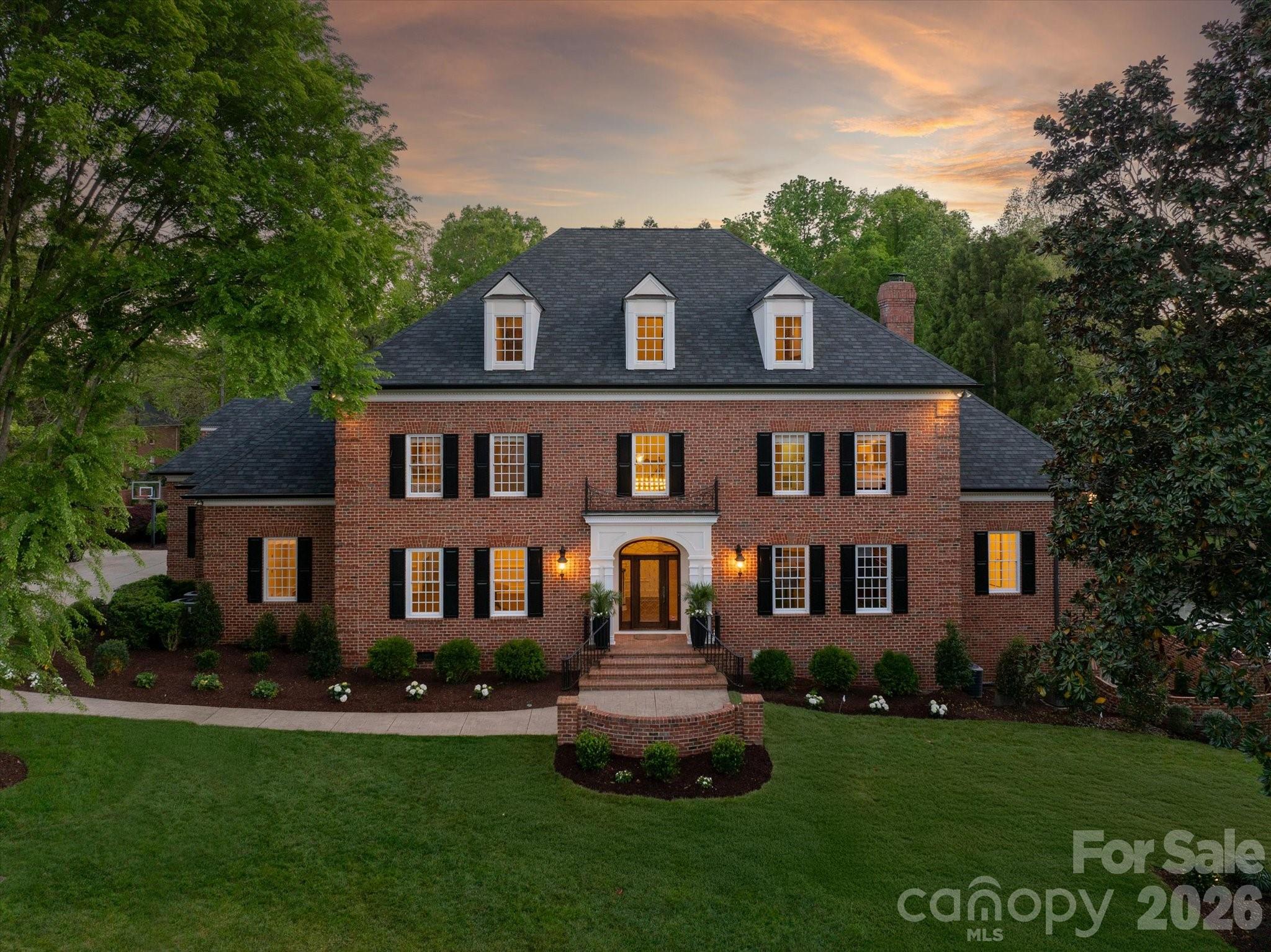 Simonini-built classic Georgian estate on a private 1+ acre lot in the gated Dovewood community, just minutes from SouthPark Mall and Phillips Place. This luxury home offers six bedrooms, six full baths, two powder rooms, and multiple bonus areas, including a fitness room and home theater, plus a third-floor climate-controlled seasonal closet.
The main entrance showcases a dramatic two-story foyer with elegant wall moldings and a richly appointed study wrapped in mahogany paneling. The main floor also features a bright, sunny primary suite with a recently updated luxury bath, including a custom-tiled shower and vessel tub. A spacious great room with built-ins and a gas fireplace opens to an amazing chef’s kitchen. The recently upgraded kitchen includes custom cabinetry, a new kitchen island, new quartzite countertops (in both the kitchen and butler’s pantry), a built-in refrigerator and freezer, a Thermador induction cooktop with commercial vent hood, Thermador dishwasher, double ovens, warming drawer, and a new workstation sink. The kitchen also includes a new scullery with open shelving, an additional prep sink, and a beverage drawer.

The walk-out basement includes a spacious home theater, wine room, and gym. The third floor offers a 275-square-foot seasonal closet, plus a bonus room and full bath. High-end finishes are found throughout, including 10-foot ceilings with custom detailing, handcrafted millwork, decorative moldings, and oak hardwood flooring.

The real gem of this home is the beautiful, tranquil grounds, featuring brick-walled gardens, mature landscaping, and multiple garden sitting areas, as well as a heated pool with a pool house for year-round enjoyment.

Located in the heart of SouthPark, this exceptional property combines timeless architecture with modern luxury—an opportunity to own a truly distinctive estate in one of Charlotte’s most desirable areas.