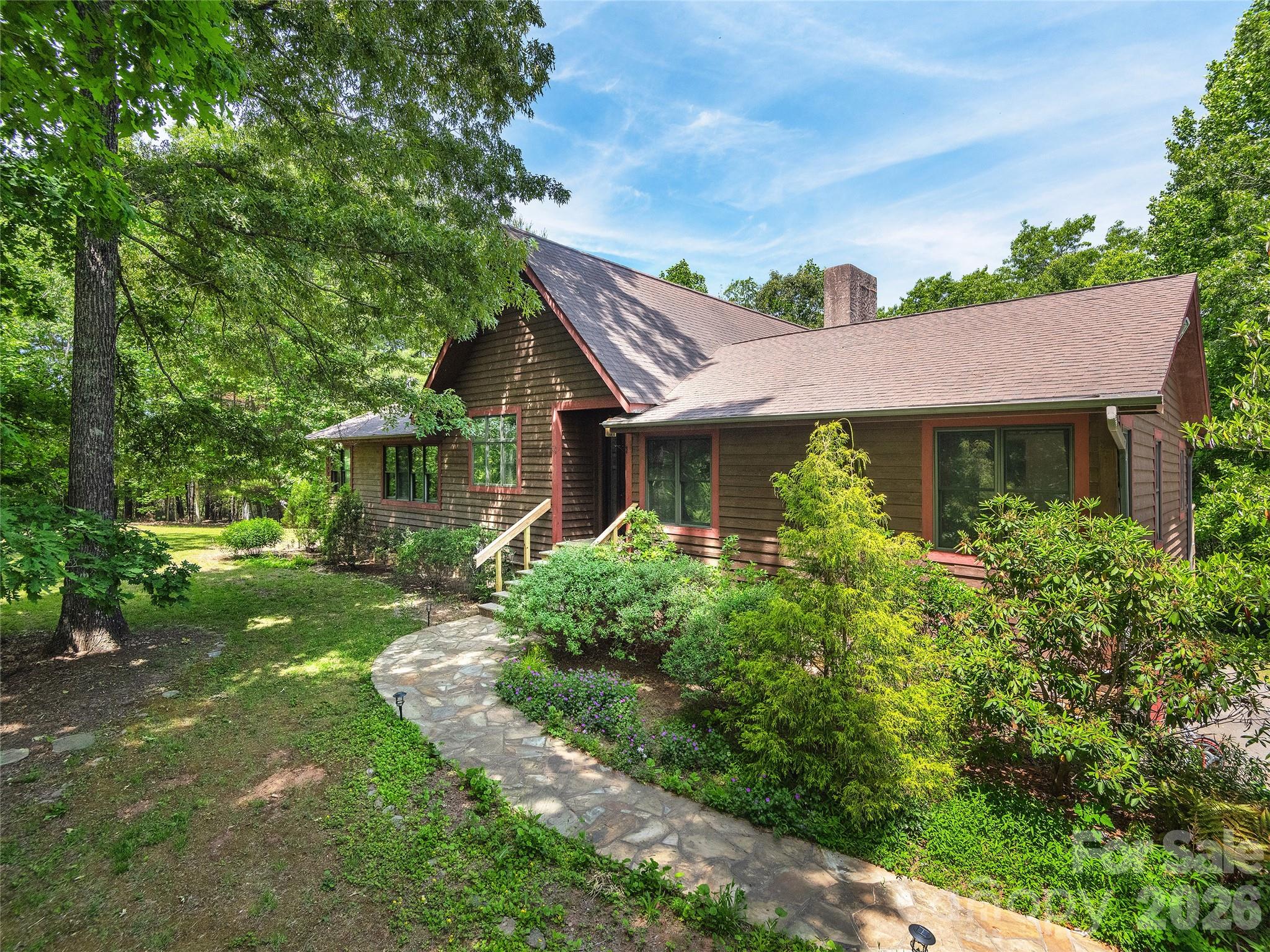 Tucked away in the heart of Mills River, this private 4.31-acre retreat offers the perfect blend of seclusion, craftsmanship, and comfort. With 3,687 heated square feet, this custom home features 3 bedrooms and 3.5 bathrooms, highlighted by soaring ceilings in the great room, an abundance of natural sunlight, and exquisite custom woodwork throughout the interior. Two impressive wood-burning stone fireplaces create warm and inviting gathering spaces, while beautiful stone sidewalks and retaining walls enhance the natural mountain setting. The spacious basement level expands the home's versatility with a large family room, media room, bonus room, and a full bathroom ideal for entertaining, guests, multigenerational living, or recreation space. A detached 1,100-square-foot garage/workshop provides exceptional space for hobbyists, collectors, or additional storage. NO DRIVE BY'S