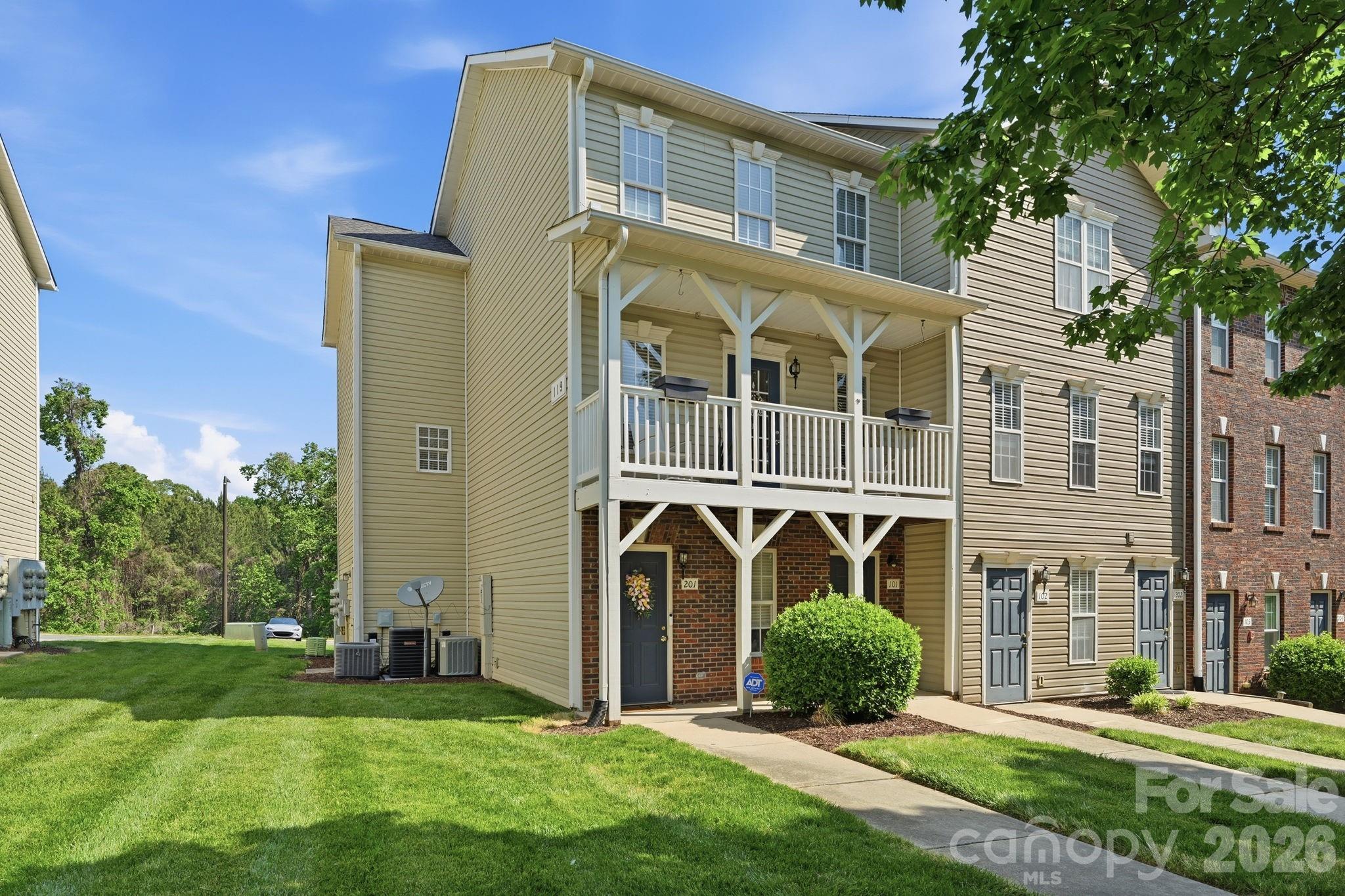 Welcome to this charming, Charleston-inspired condo offering stylish finishes, flexible living space, and a low-maintenance lifestyle in a desirable setting. Situated along a pretty tree-lined street, this home features both a covered front porch and a private covered balcony, along with a back deck, creating inviting outdoor spaces with timeless curb appeal. Inside, the main level showcases LVP with the look of wide-plank flooring, neutral paint tones, and updated lighting throughout. The spacious living room is anchored by a striking electric fireplace with floor-to-ceiling stone, while the dining area opens to a rear deck overlooking a peaceful natural area, perfect for relaxing or entertaining. The kitchen offers white cabinetry, stainless and black appliances, under-cabinet lighting, a large pantry, functional design details, and ample prep space. Upstairs, the primary suite provides a comfortable retreat with 2 walk-in closets and an ensuite bath. Two additional bedrooms offer versatility for guests, home office, or hobby space, all complemented by a second full bath. Additional features include a Google Nest system, video doorbell, wired smoke detectors, and fire sprinkler system for added peace of mind. Washer, drryer and refrigerator are included (as is), making this condo move-in ready. No garage, yet there is on-street parking plus a rear parking area that provides convenient access with ample space for residents and guests. The community enhances everyday living with natural green space, a dog-friendly recreation area, and exterior/landscaping maintenance included. Continuum 115 apartments offers an OPTIONAL membership to their nearby pool, fitness center, and clubhouse for a low $50/month additional fee to residents of Station 115. Great location, convenient to Lowe's Corporate Headquarters, Lake Norman Regional Medical Center, quaint downtown Mooresville, shopping, dining, all not far from I-77.